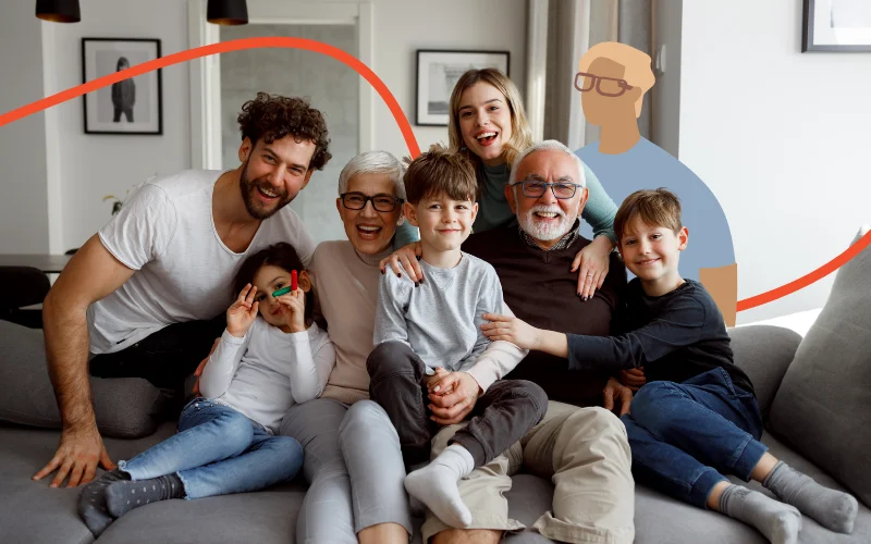 Stor familie sidder i sofa og smiler