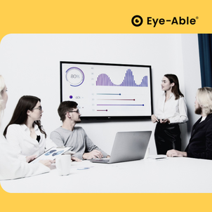 A woman stands in front of a television and gives a presentation to four people sitting at a desk