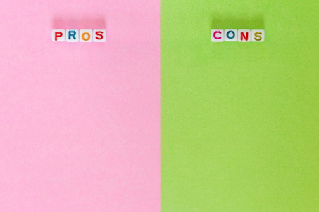 The word "pros" on the left side on rose background and the word "cons" on the right on green background.