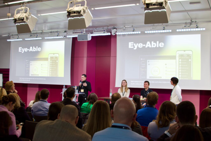 Chris Schmidt, Mitbegründer von Eye-Able, hält eine Rede vor zahlreichen Zuhörern.
