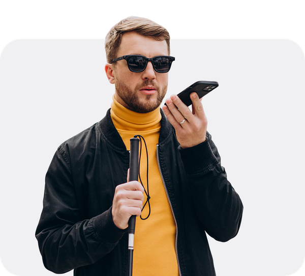 Mann mit Sonnenbrille und Blindenstock nutzt die Sprachausgabe seines Smartphones.