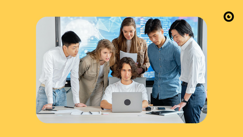 Interested people stand in front of a laptop