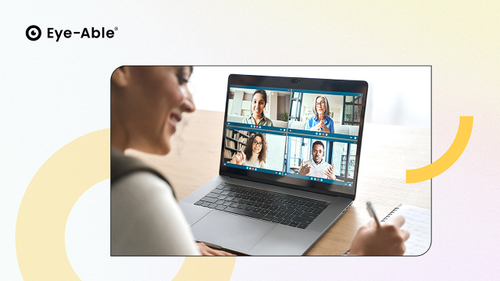 Frau sitzt am Laptop und ist in einem Meeting mit vier Personen