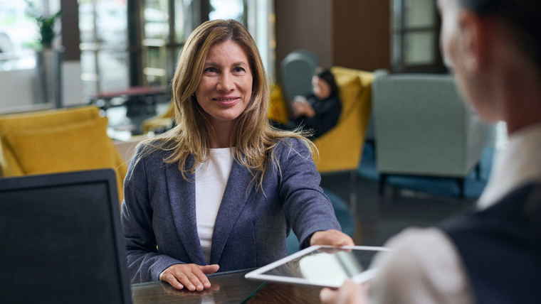 Businesswoman handing over a tablet to a client in a professional environment