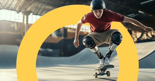 A young man with two prosthetic legs is skateboarding in a halfpipe. He wears a helmet and knee pads. The setting feels athletic and empowering.