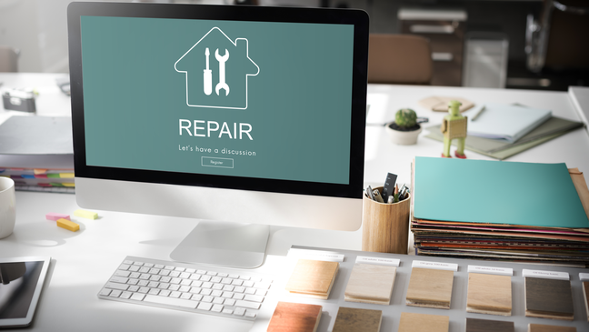 Computer with repair logo on the screen and materials on the desk