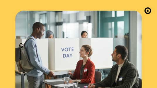 A man stands in front of two poll workers and accepts the voting documents
