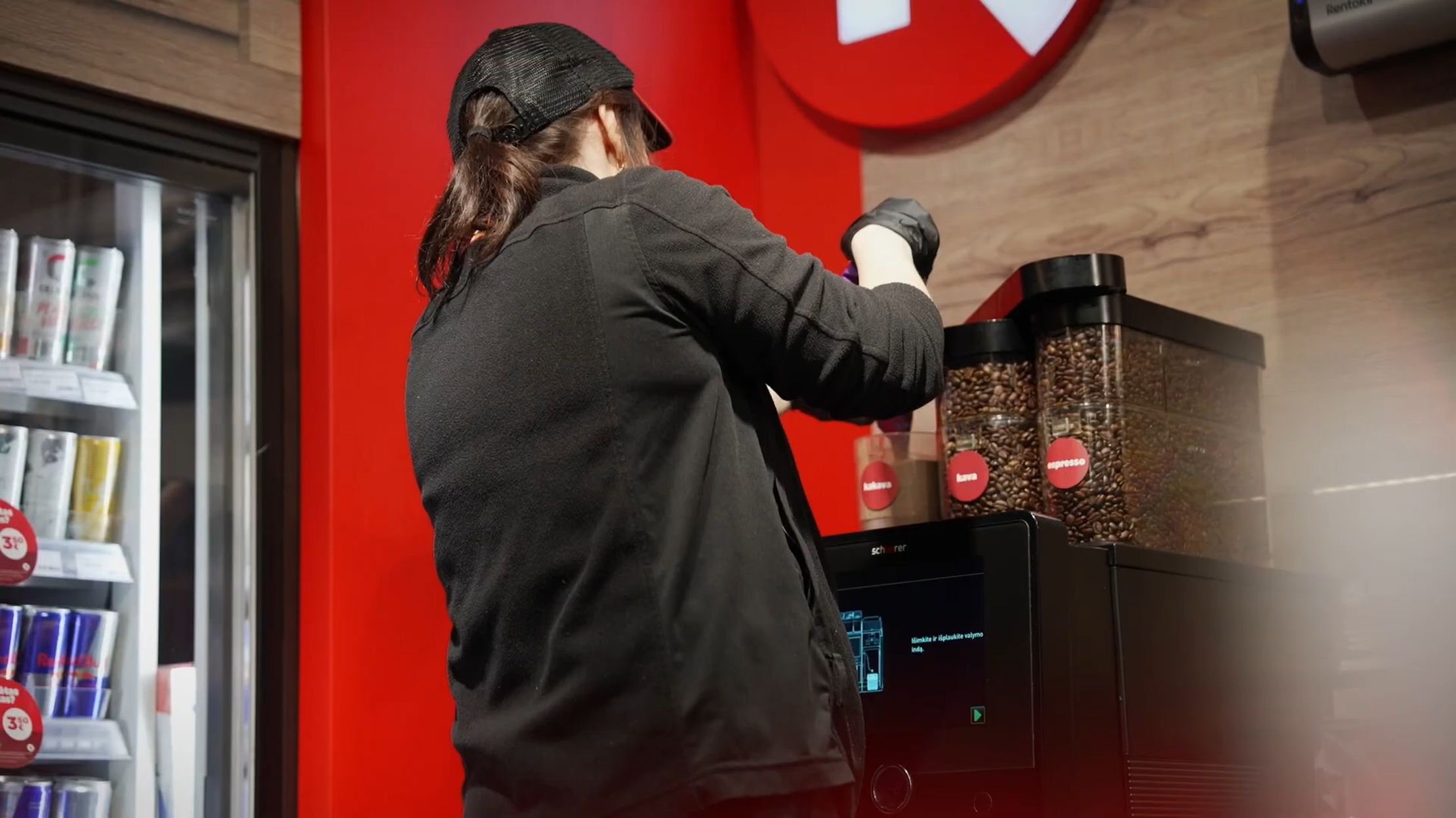 Employee refilling coffee beans at Schaerer coffee machine