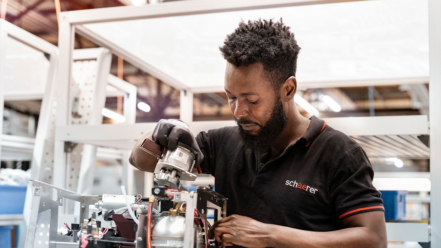 A man in a black shirt works in a factory