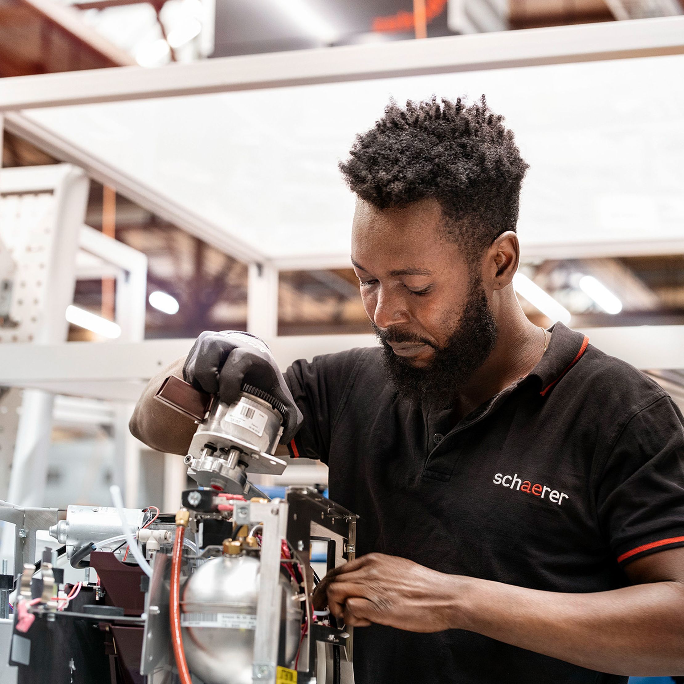 A man in a black shirt works in a factory