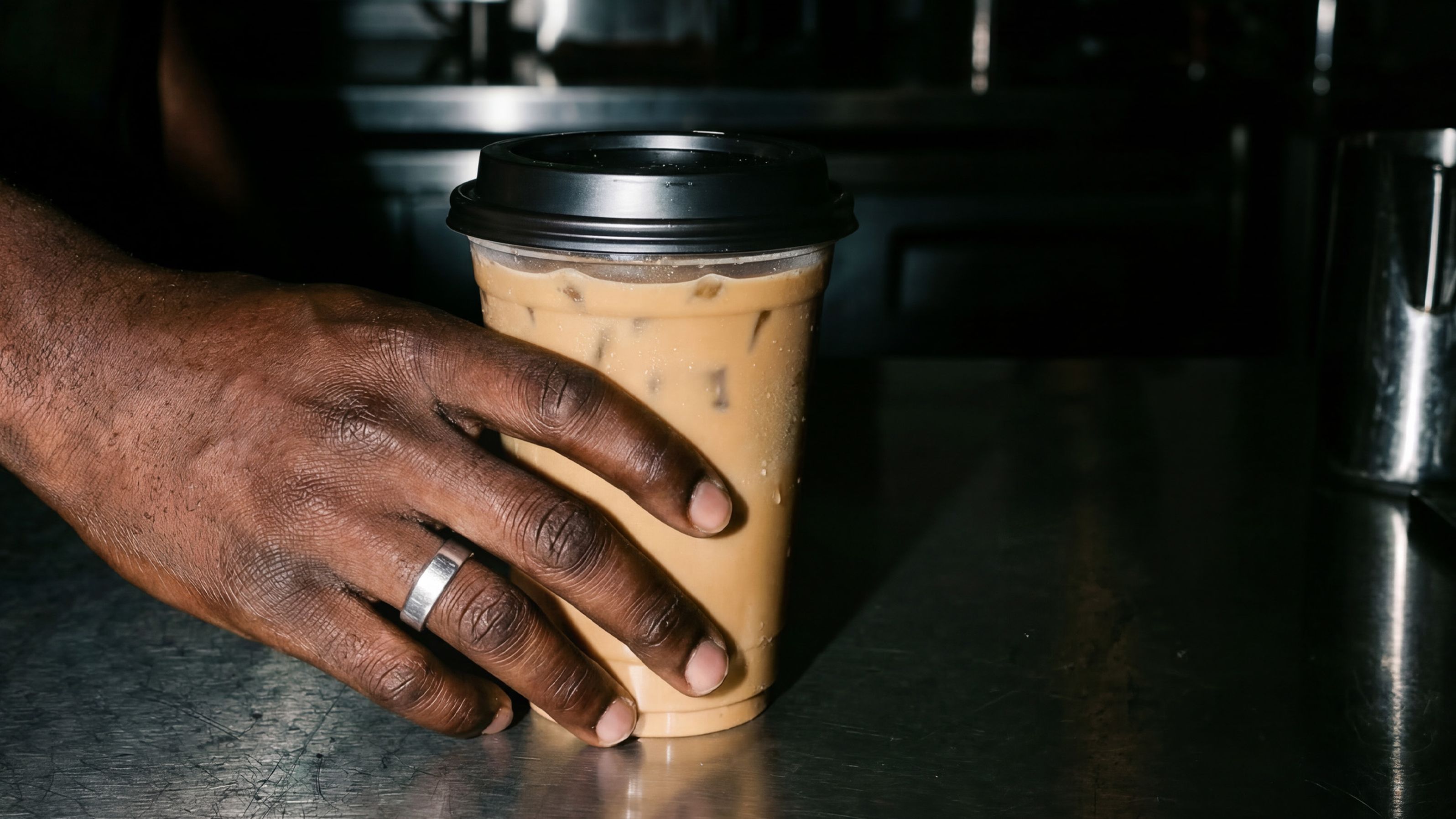 Hand with ice coffee teaser