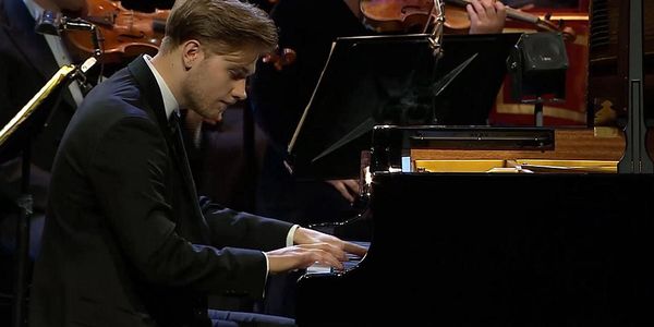 Mikołaj Ólafur Frach performing on the piano during a concert