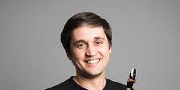 Vitaly Vatulya posing in a black t-shirt with his saxophone