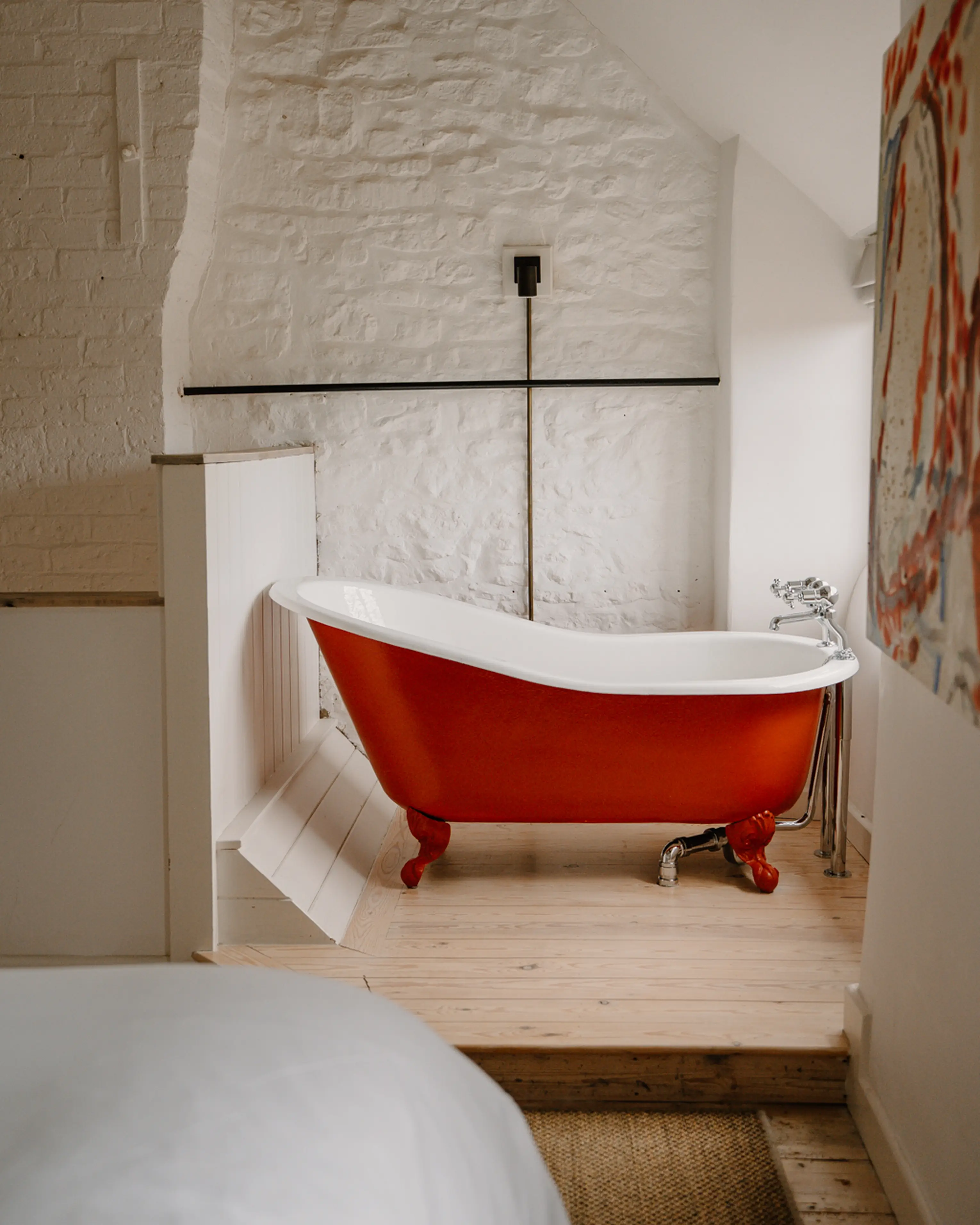Red roll-top clawfoot bath in a white eaves bathroom at ARC Painswick