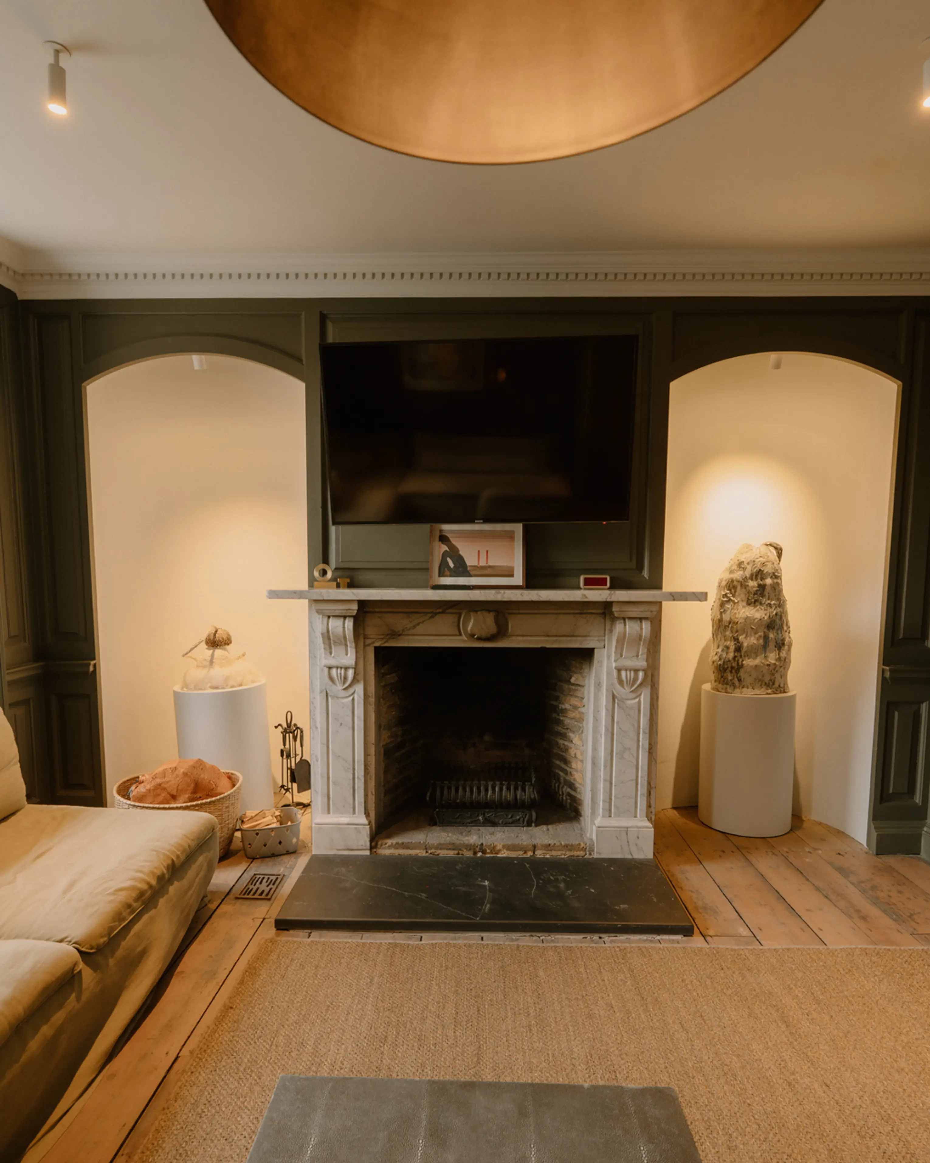 Living room at ARC Padstow with a large restored stone fireplace set between arched alcoves