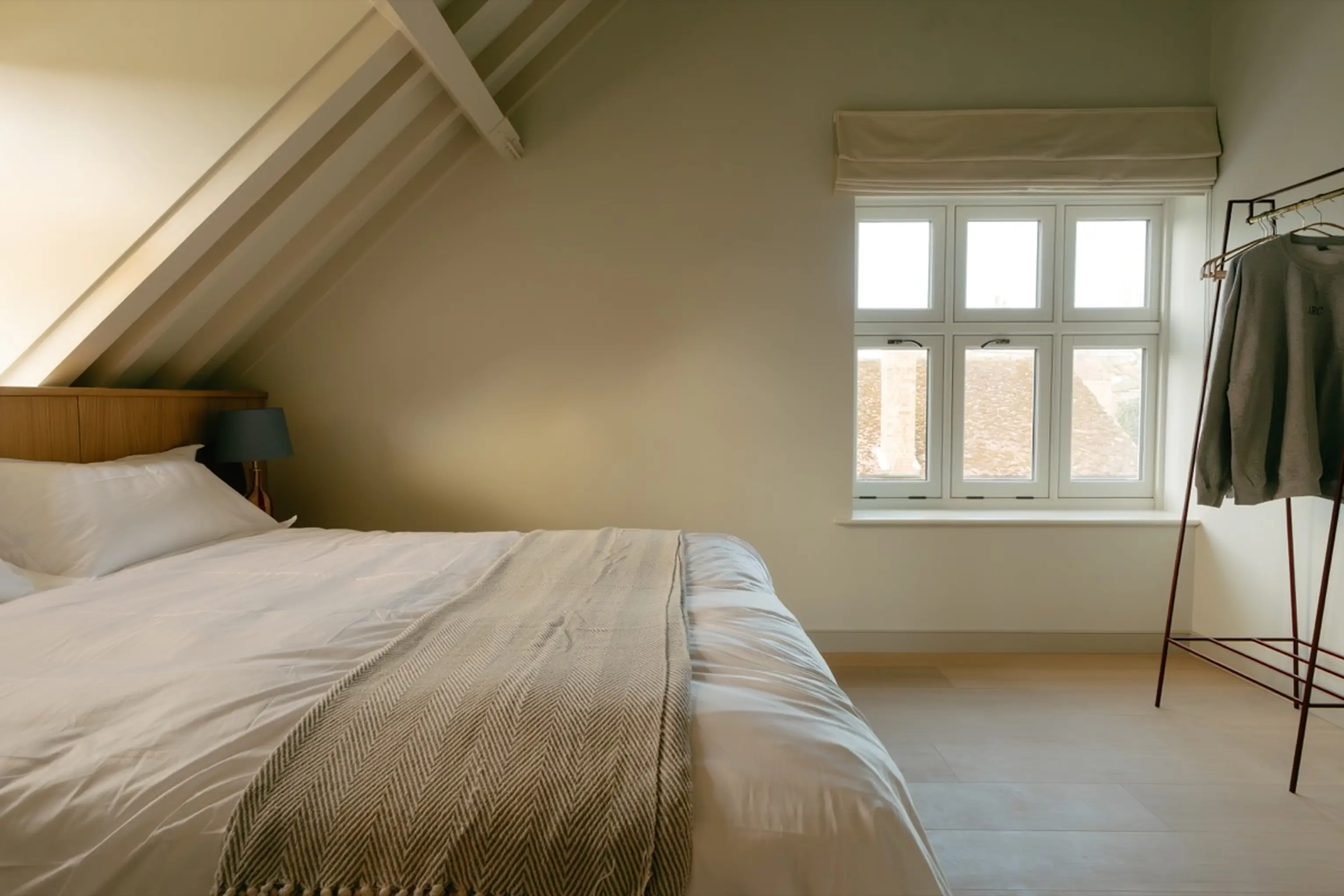Bedroom at ARC Next-the-Sea with a white bed, hanging rail and a window