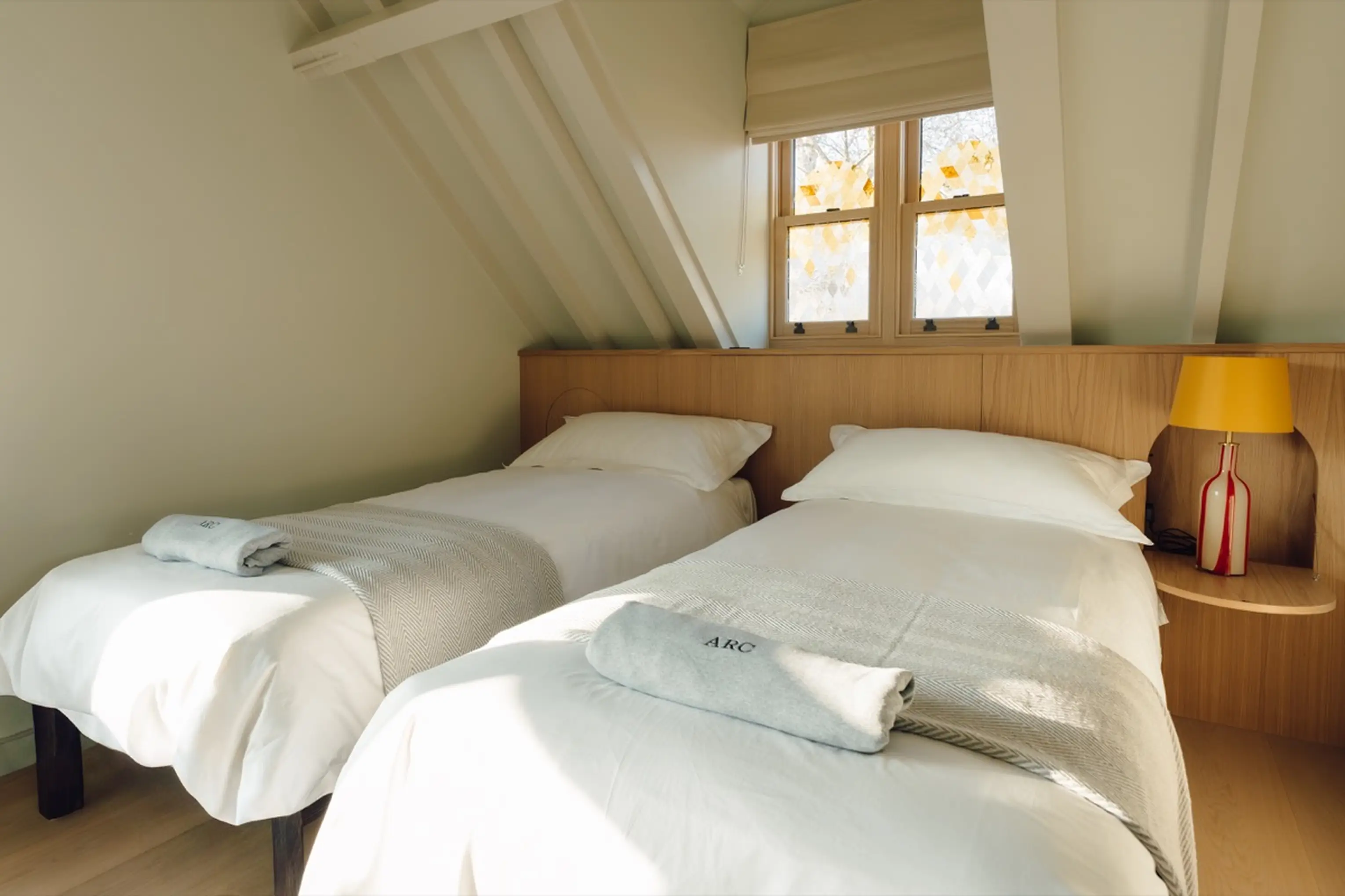 Twin bedroom at ARC Next-the-Sea with two beds and a bedside lamp