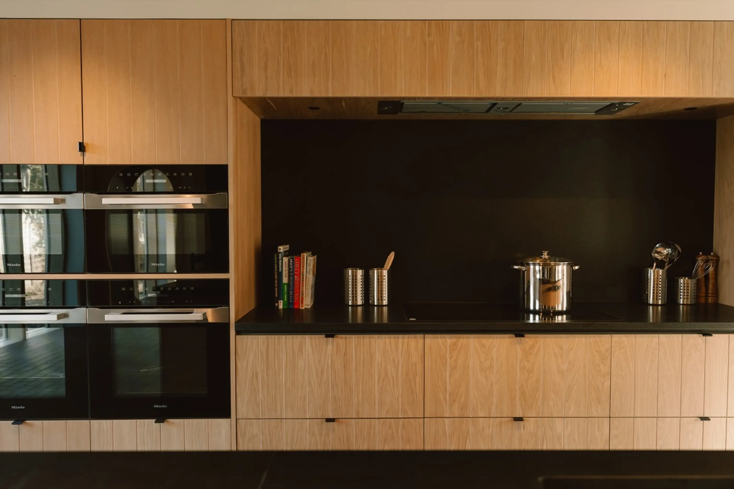 Kitchen and bar area at ARC Next-the-Sea with dark units, ovens and a coffee station