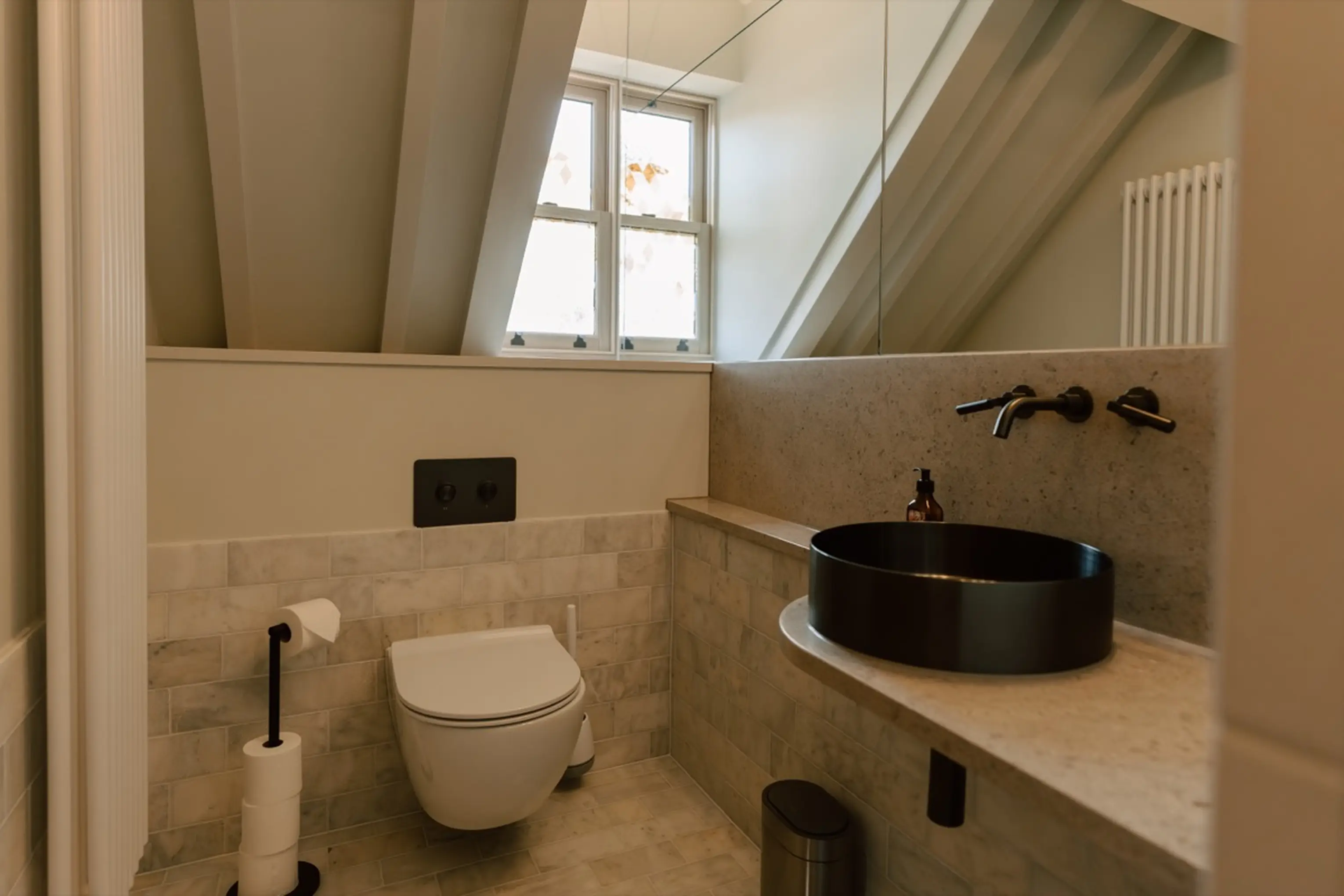 Bathroom under the eaves at ARC Next-the-Sea with a black vessel basin and a window