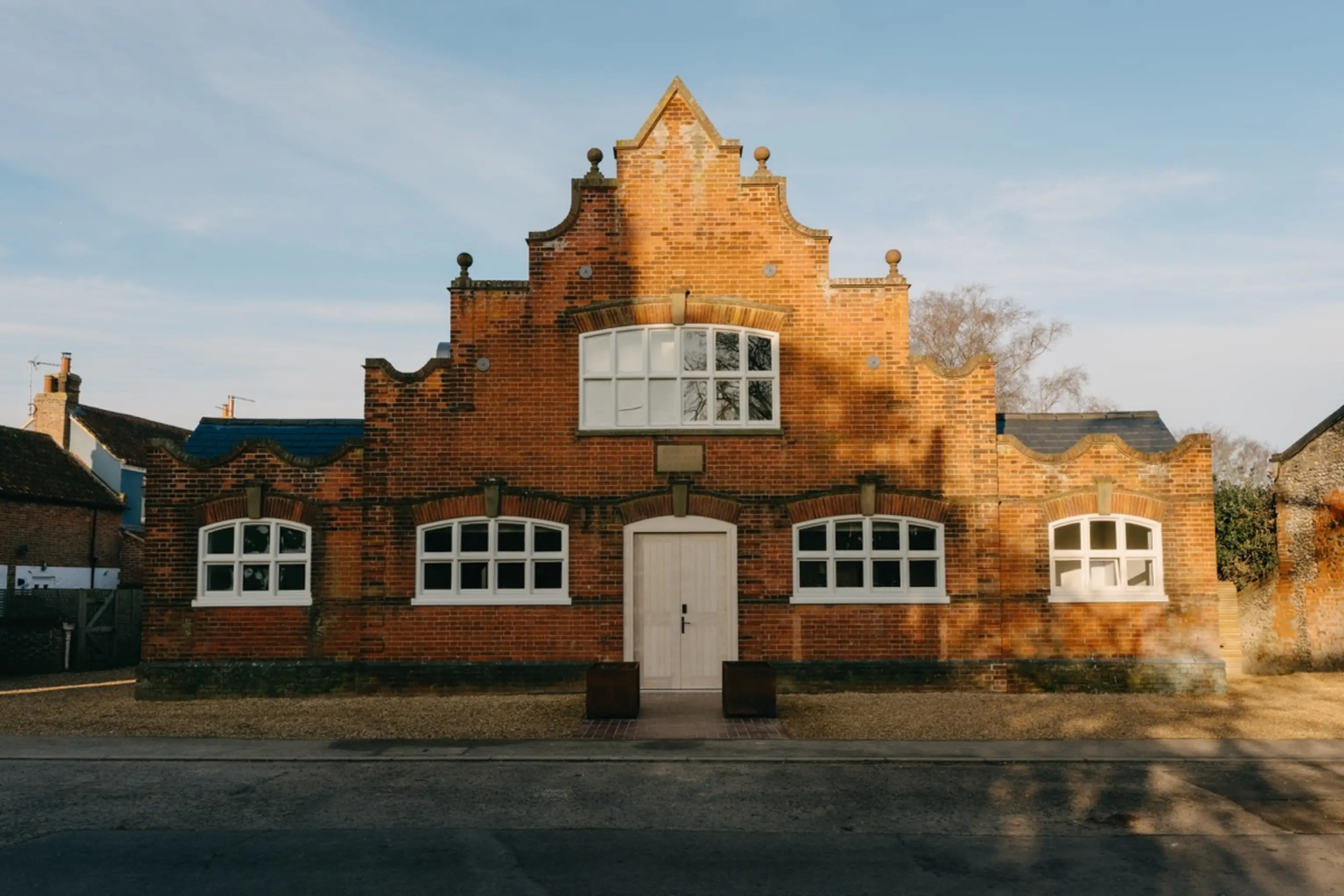 The red-brick exterior of ARC Next-the-Sea, converted from former church rooms, in the evening light