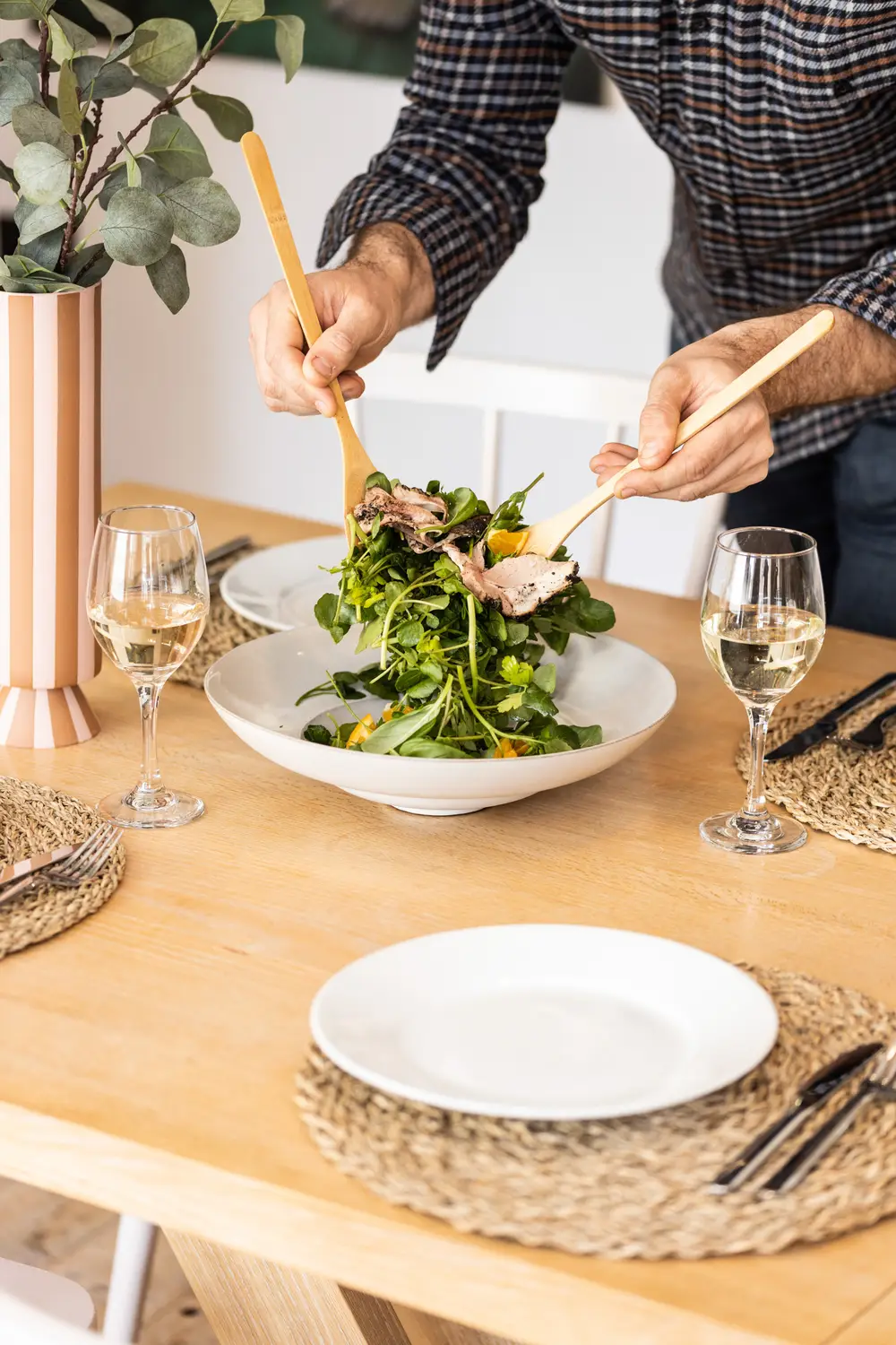 A private chef at ARC Next-the-sea cooking a custom catered meal for a group staying at this Norfolk accommodation. Pictured is a salad made with dietary restrictions for guests and a wine pairing.
