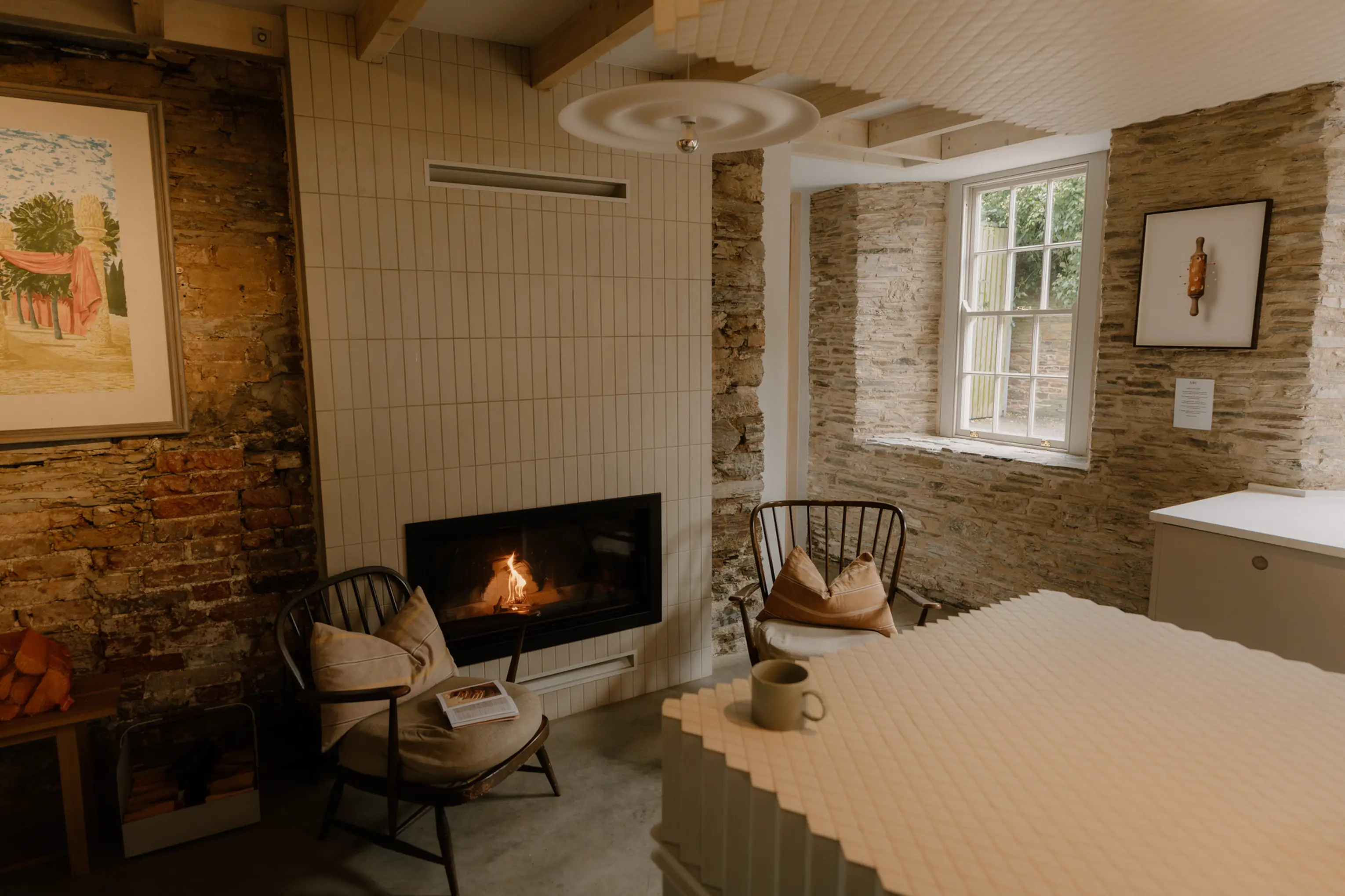 Beamed kitchen and dining space at ARC Padstow with a fireplace and garden window
