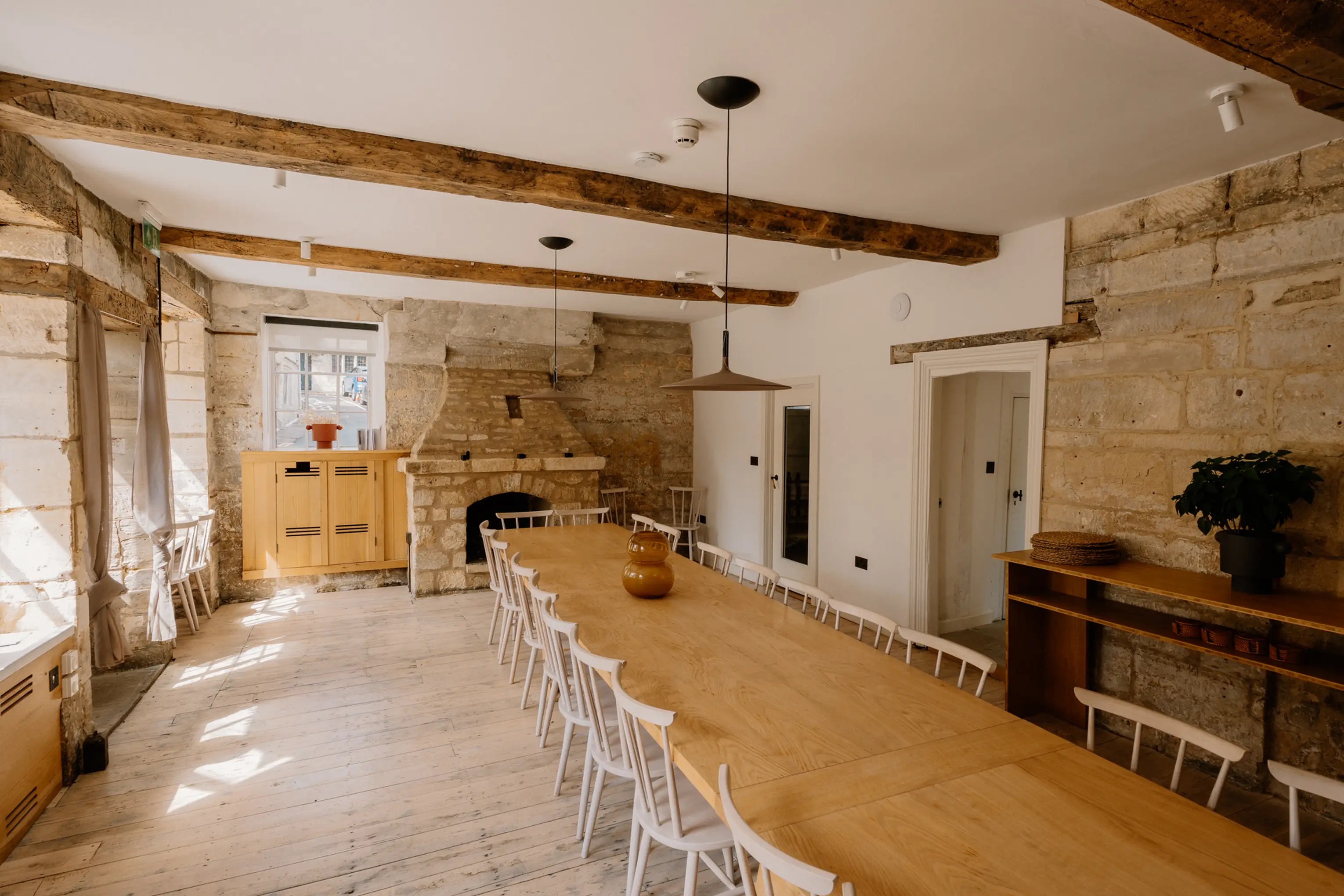 Long dining room at ARC Painswick with a timber table, benches and a beamed ceiling