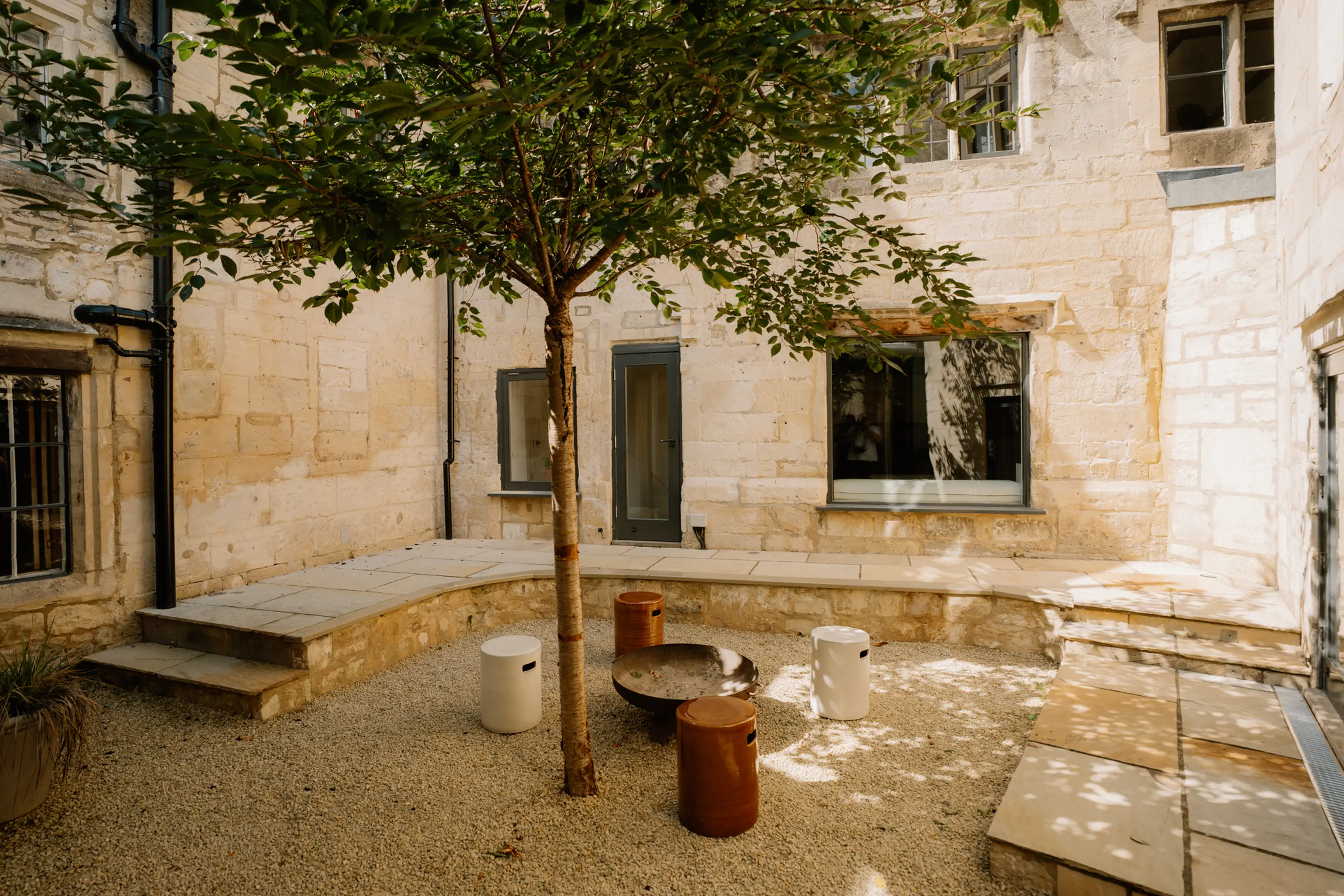 Characterful internal courtyard at ARC Painswick with a tree and stone walls