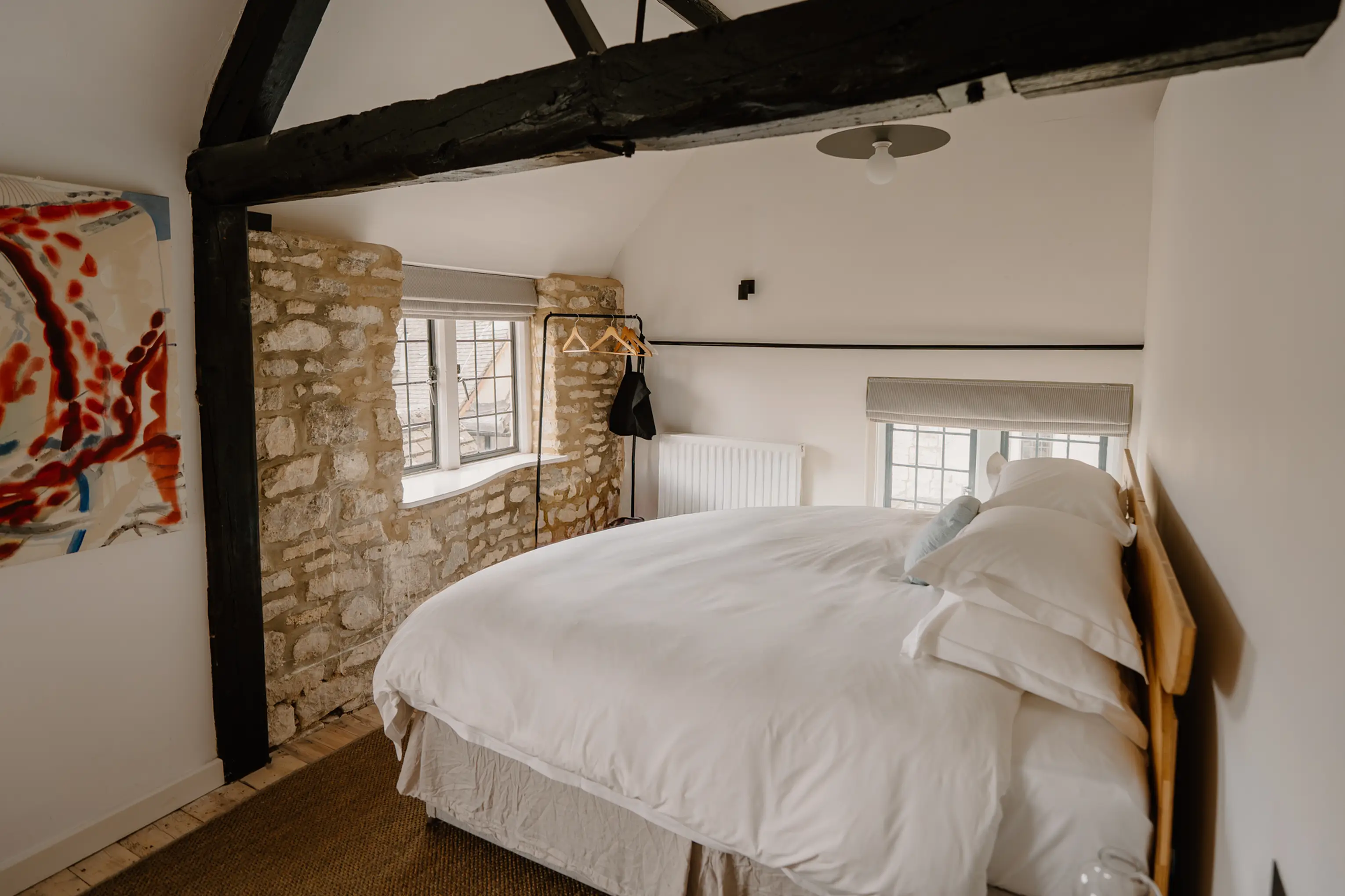 Superking bedroom at ARC Painswick with a stone wall and exposed beam