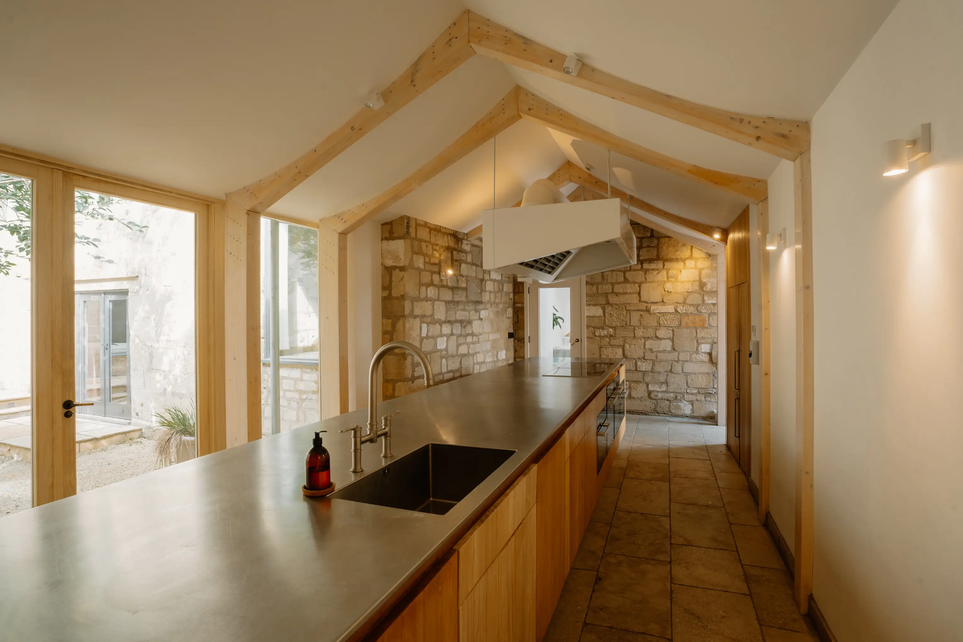 Kitchen island at ARC Painswick with glass doors opening to the courtyard