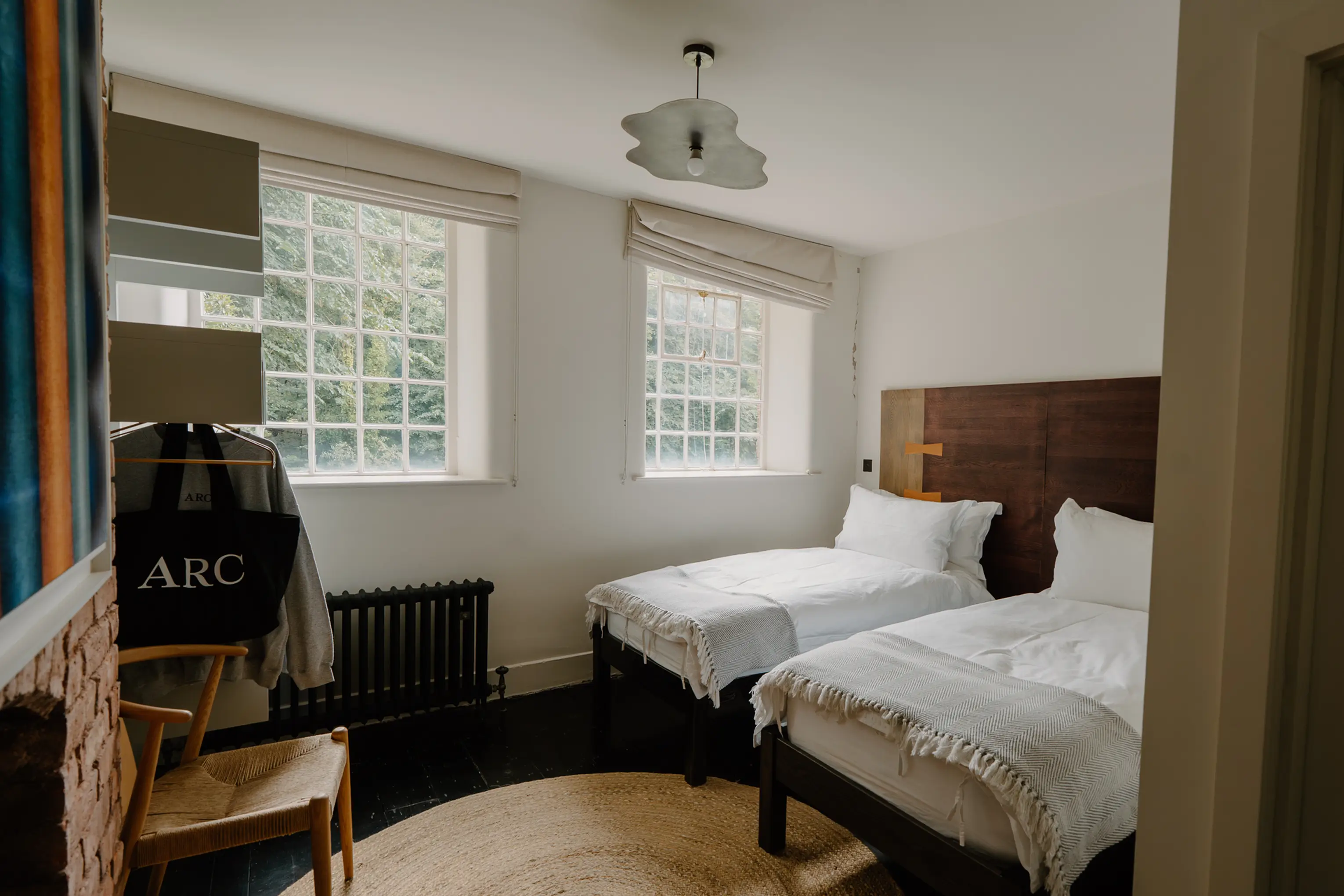 Twin bedroom at ARC Peaks with two beds, a dark headboard and colourful artwork