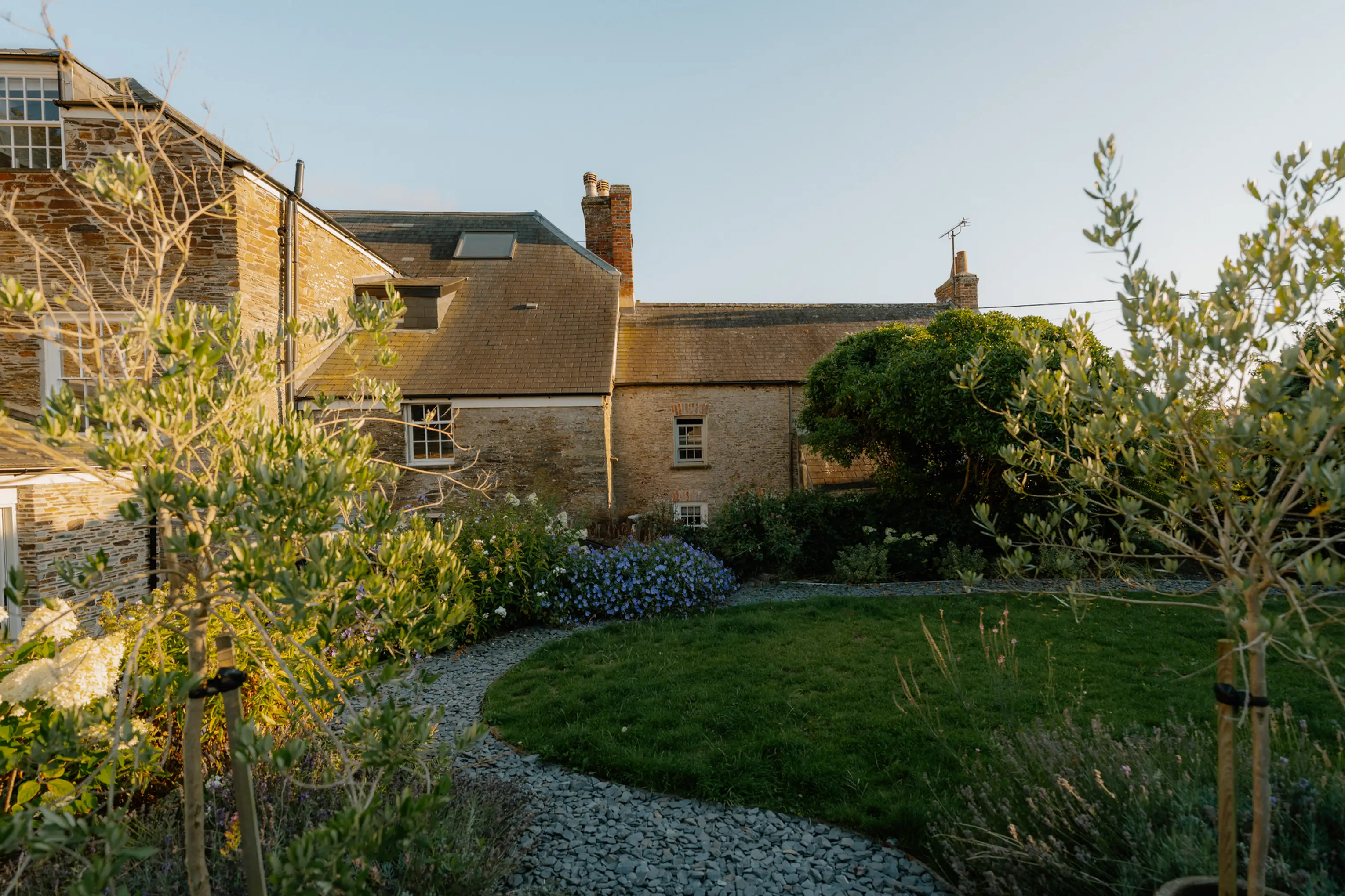 Landscape garden with a curved gravel path, flower beds and lawn at ARC Padstow