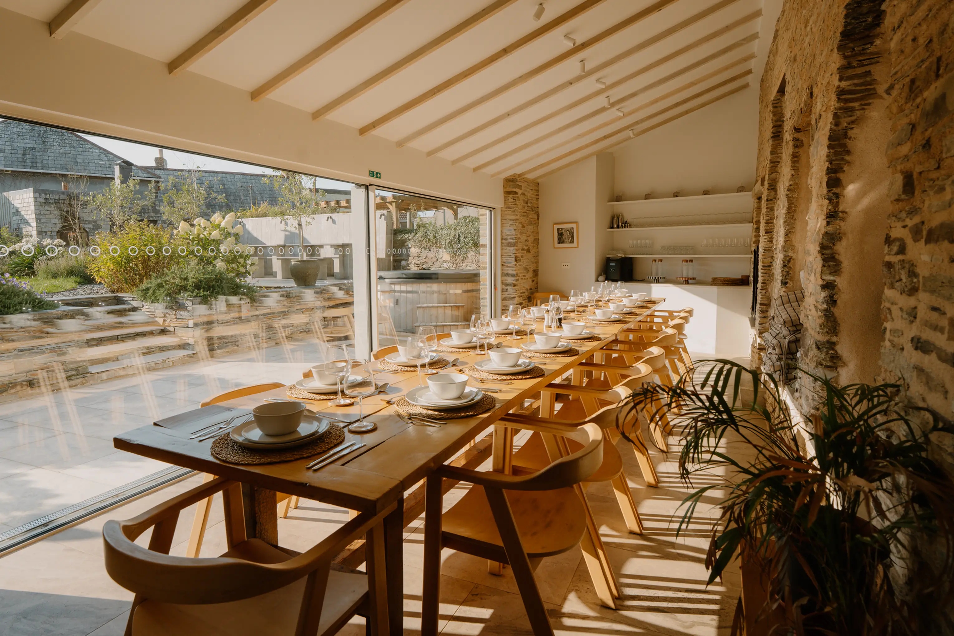 Indoor dining table at ARC Padstow in modern glass conservatory overlooking the garden
