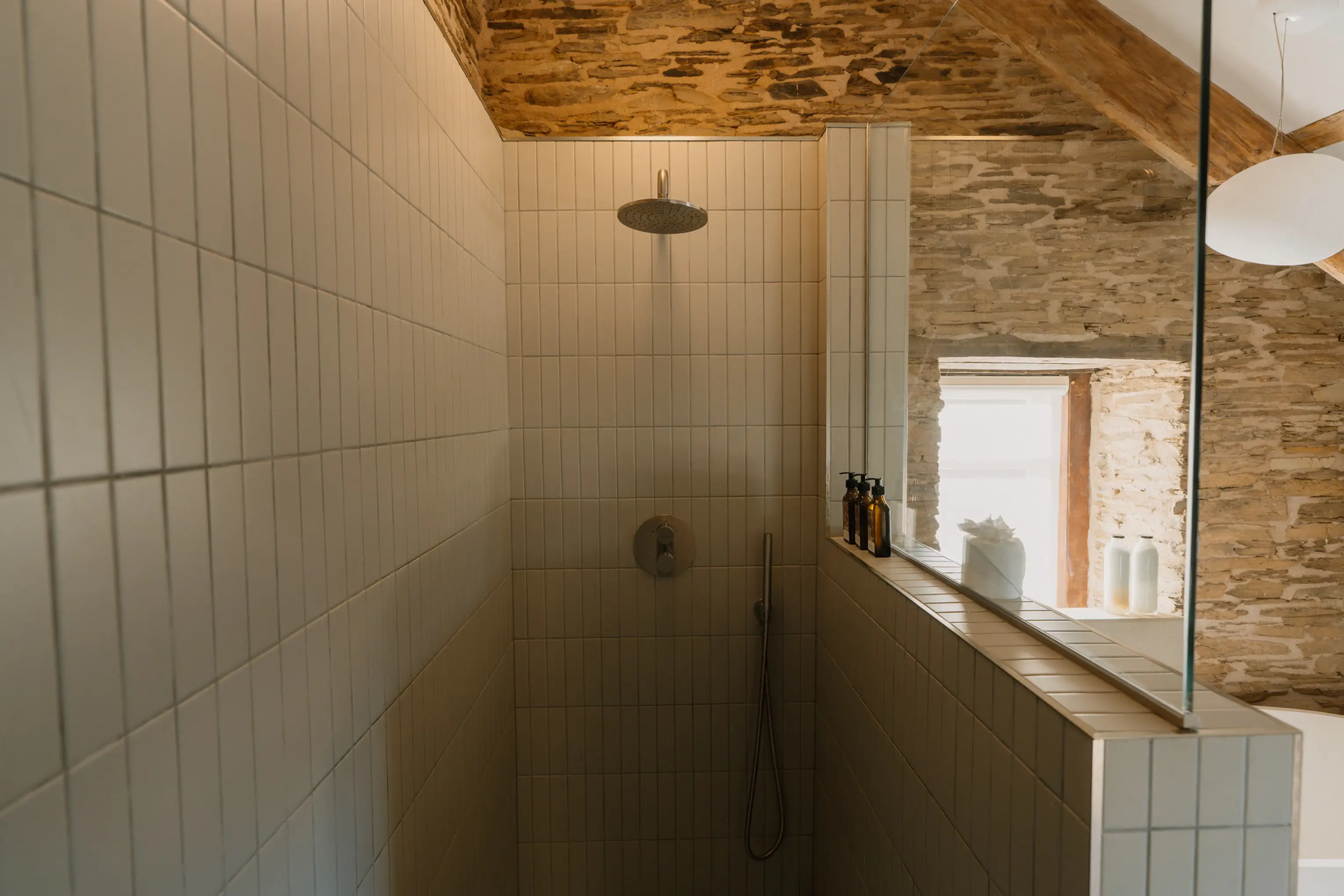 Bright white shower room at ARC Padstow with a window
