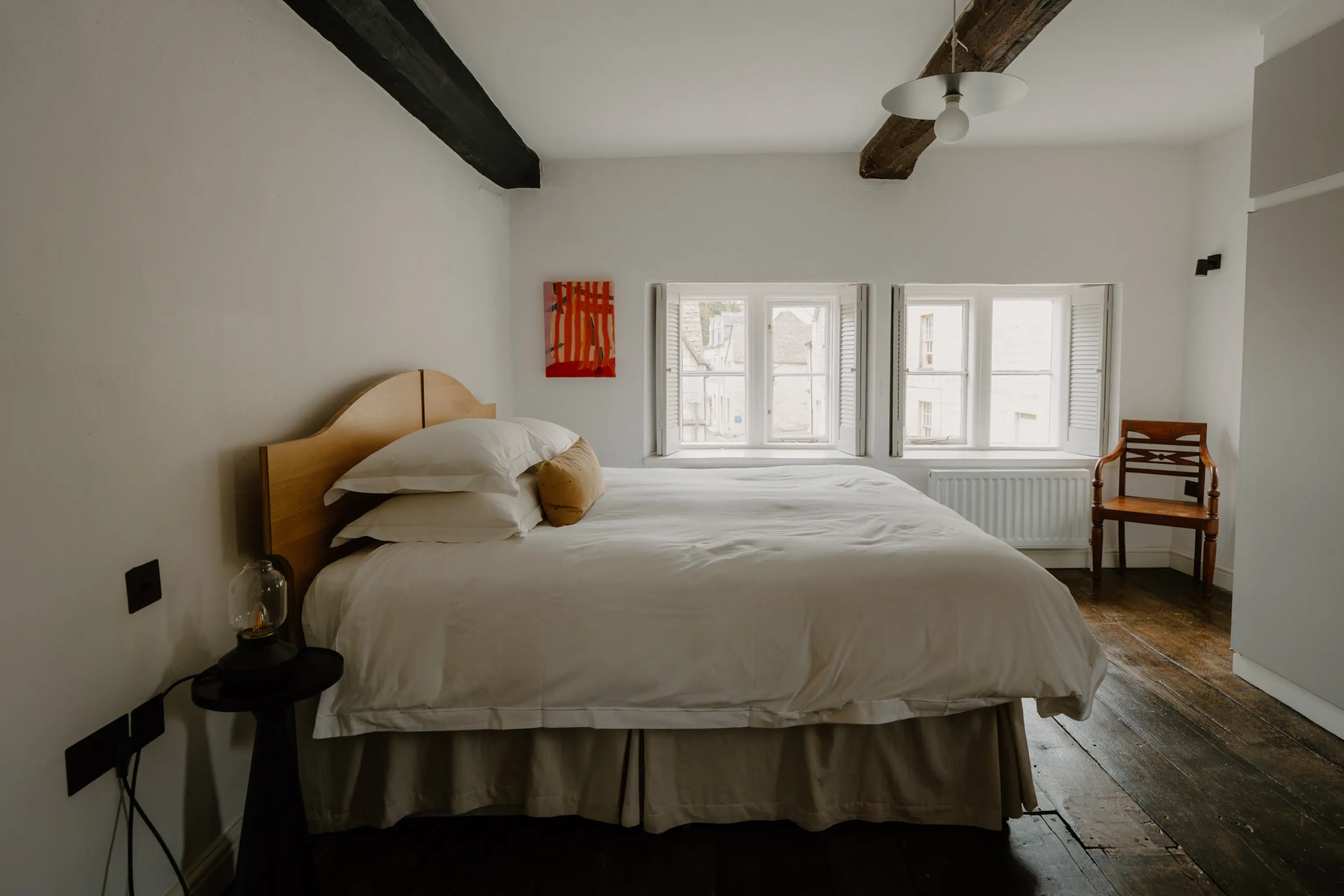 Superking bedroom at ARC Painswick with exposed beams and artwork by the window