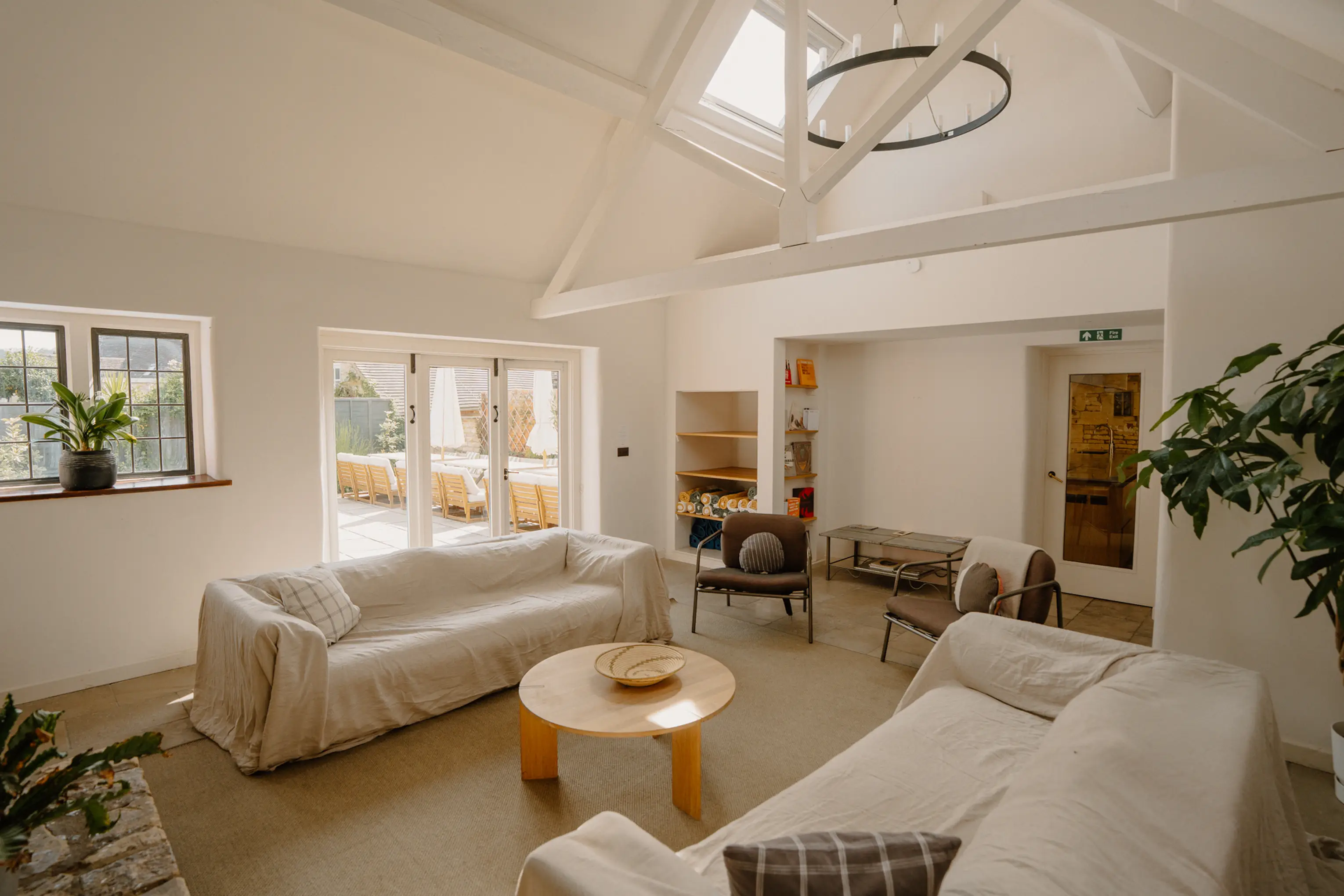 Open lounge at ARC Painswick with white sofas, a round coffee table and large windows