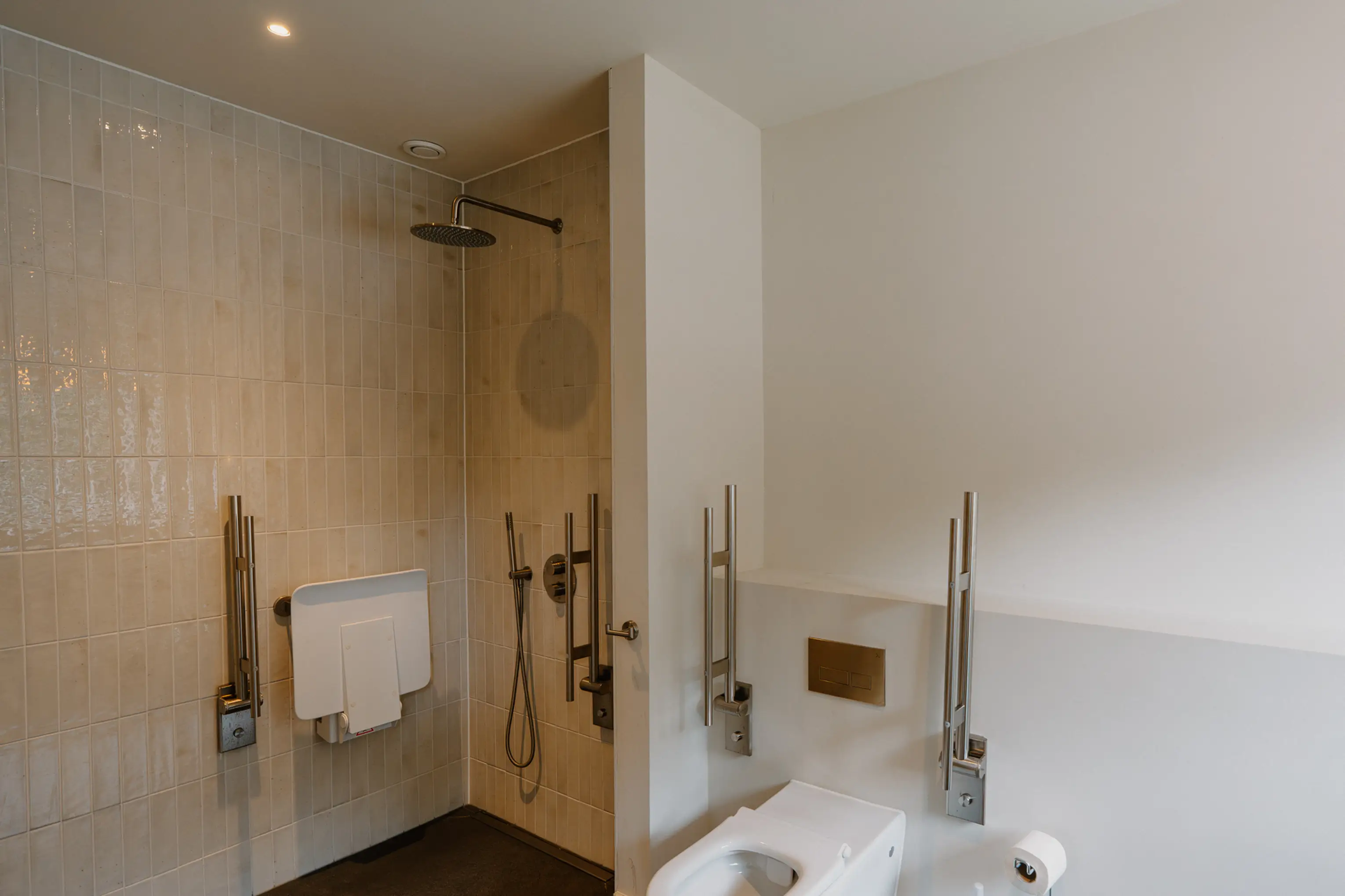 Accessible bathroom at ARC Peaks with a walk-in shower, bath and grab rails