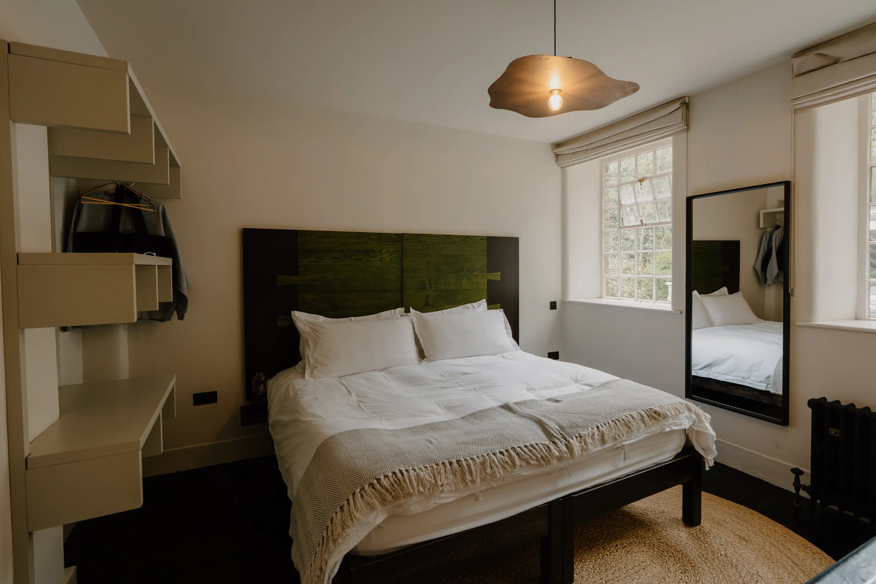 Superking bedroom at ARC Peaks with a green upholstered headboard and open shelving