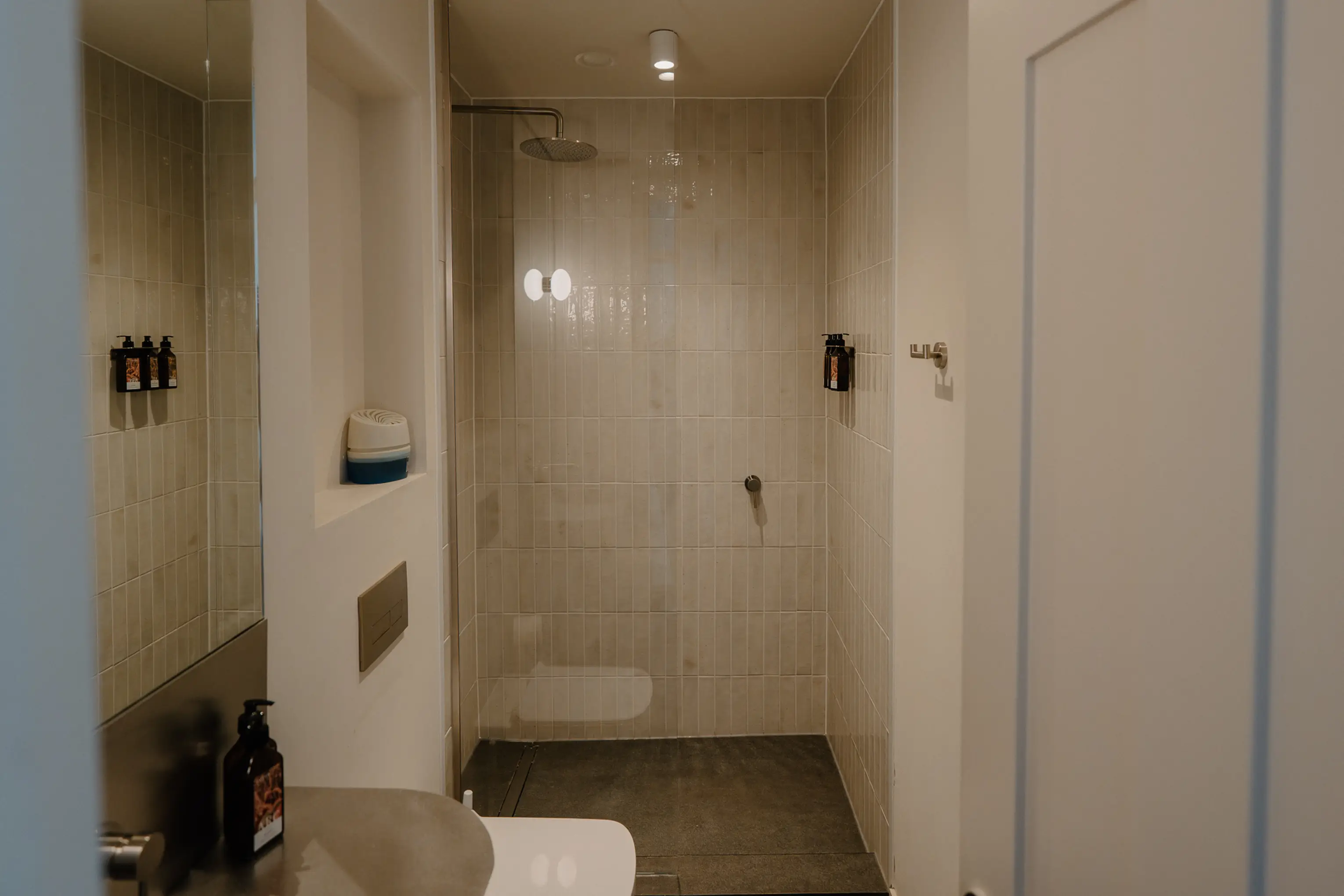 Tiled walk-in shower with a sliding door at ARC Peaks