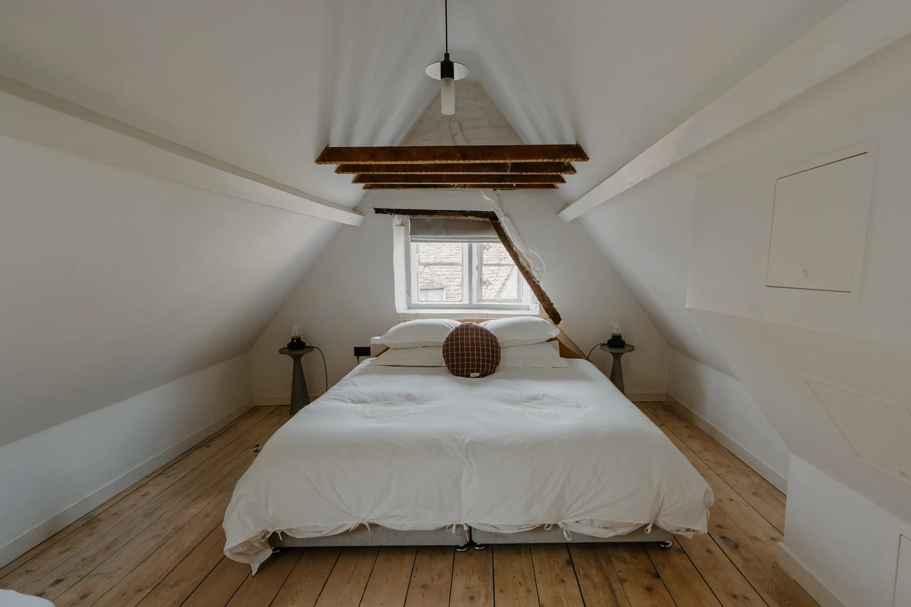 Attic double bedroom at ARC Painswick under steep eaves with a pendant light