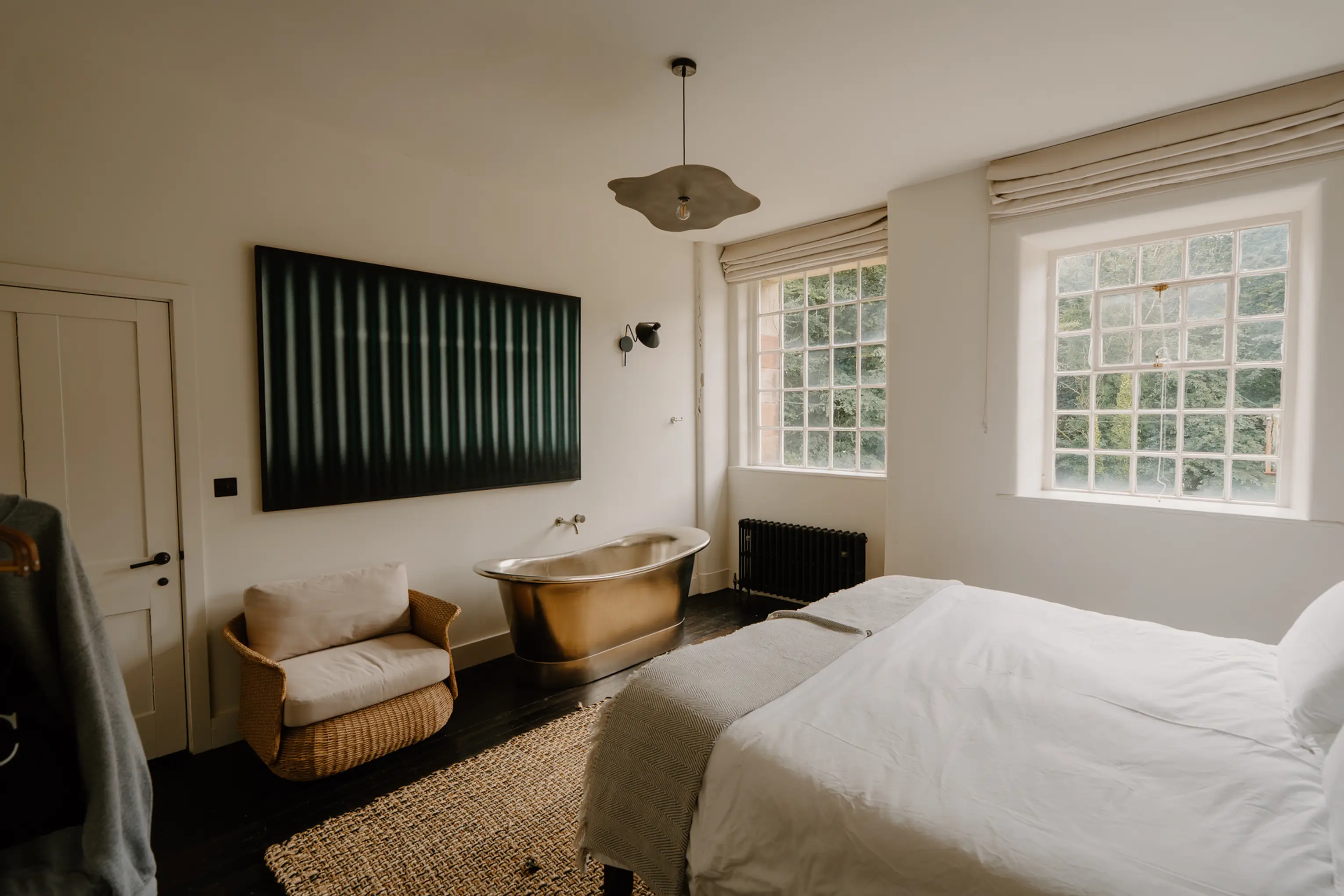 Superking bedroom at ARC Peaks with a dark green panelled headboard wall and tall windows