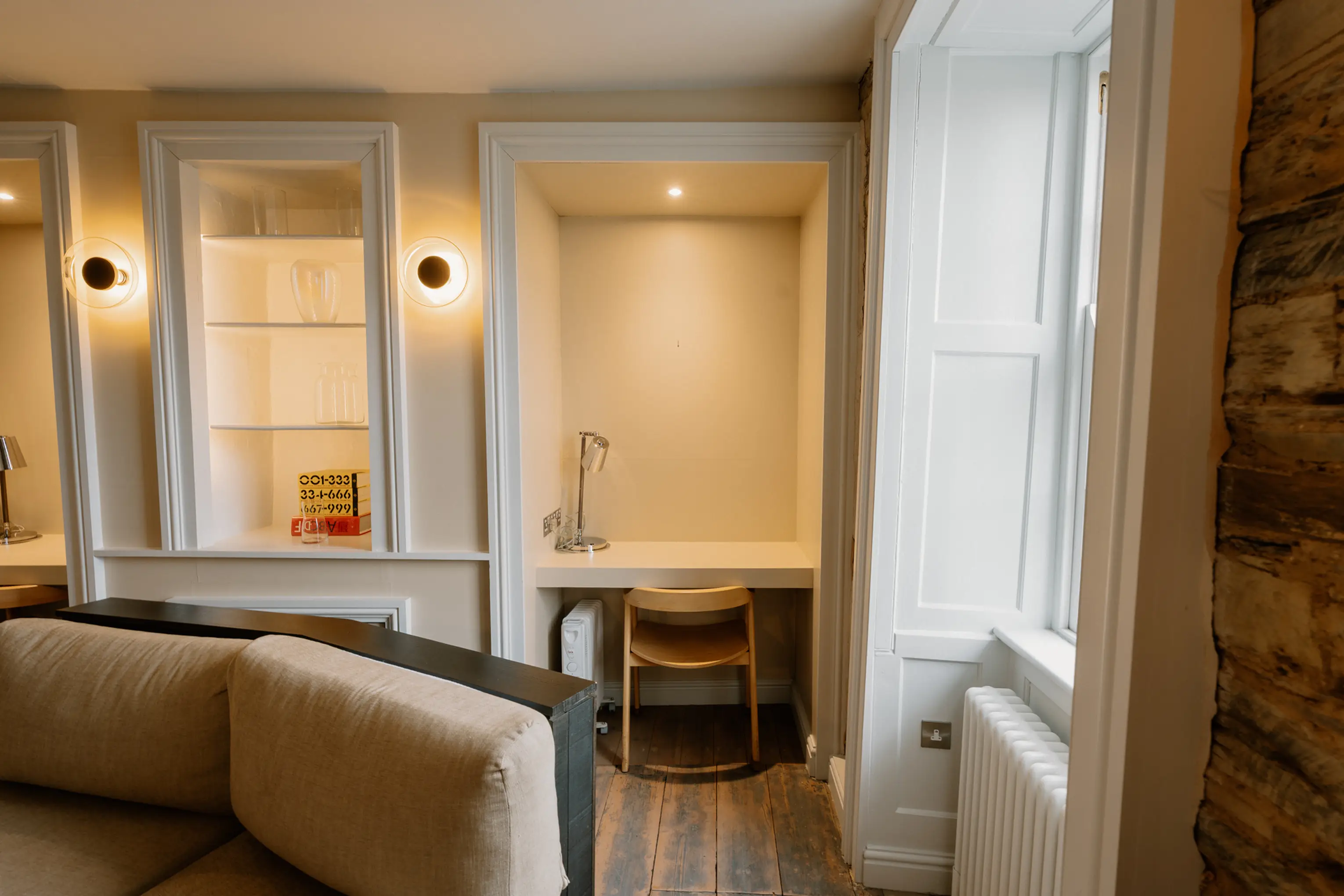 Open-plan living and seating area at ARC Padstow with garden views through tall windows