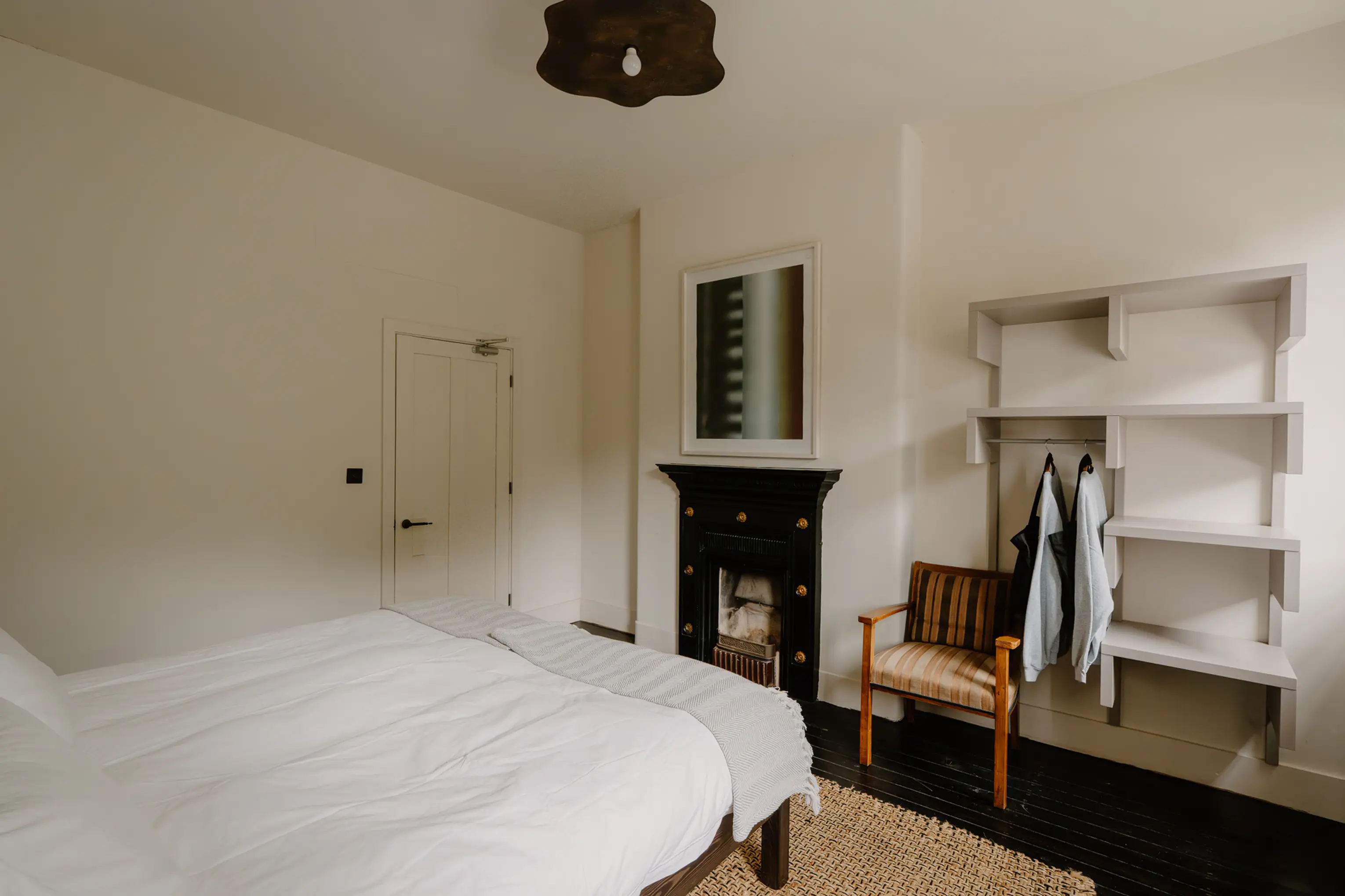 Bedroom at ARC Peaks with open shelving, a black fireplace and a reading chair