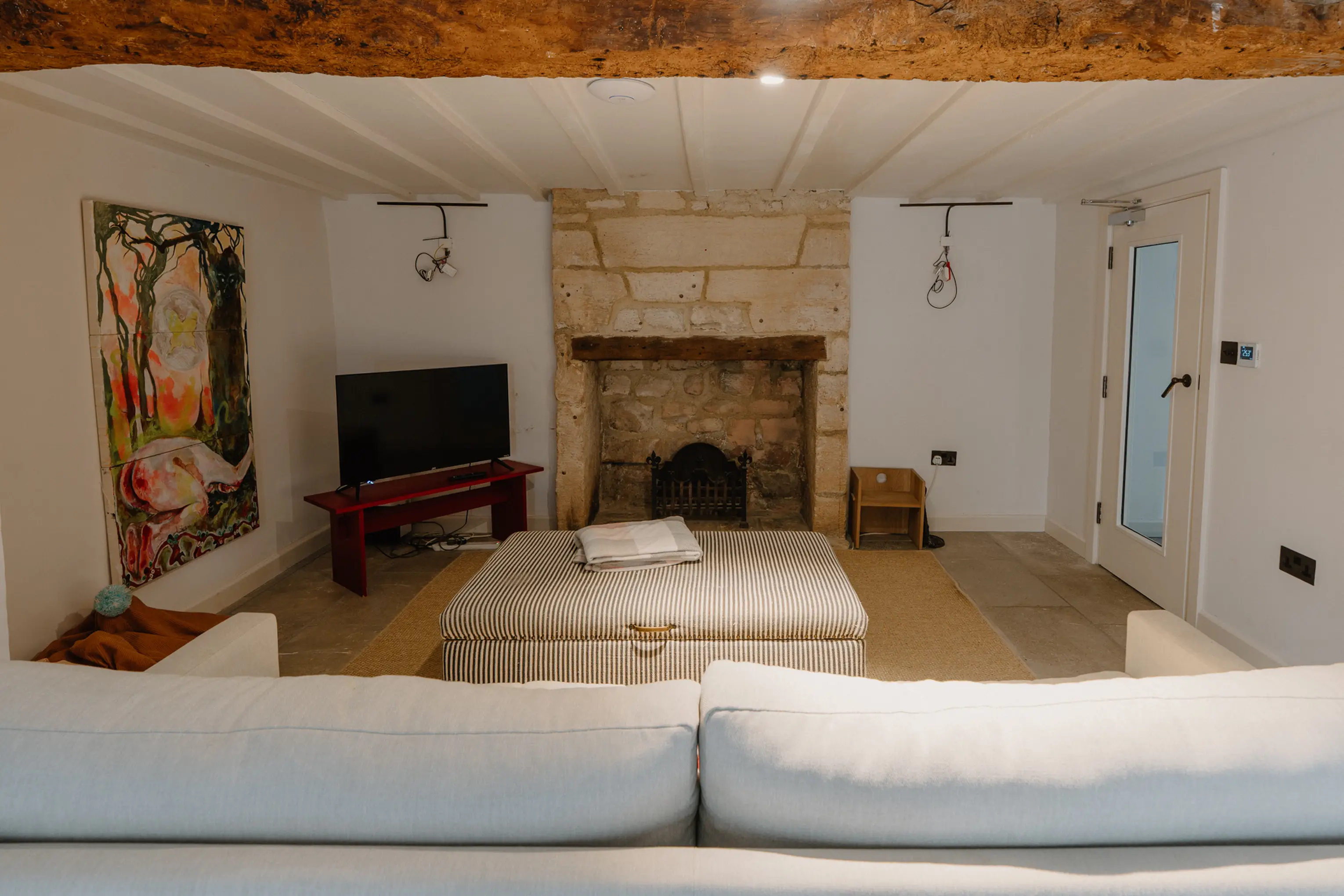 Cinema snug at ARC Painswick with a deep sofa, stone fireplace and a TV