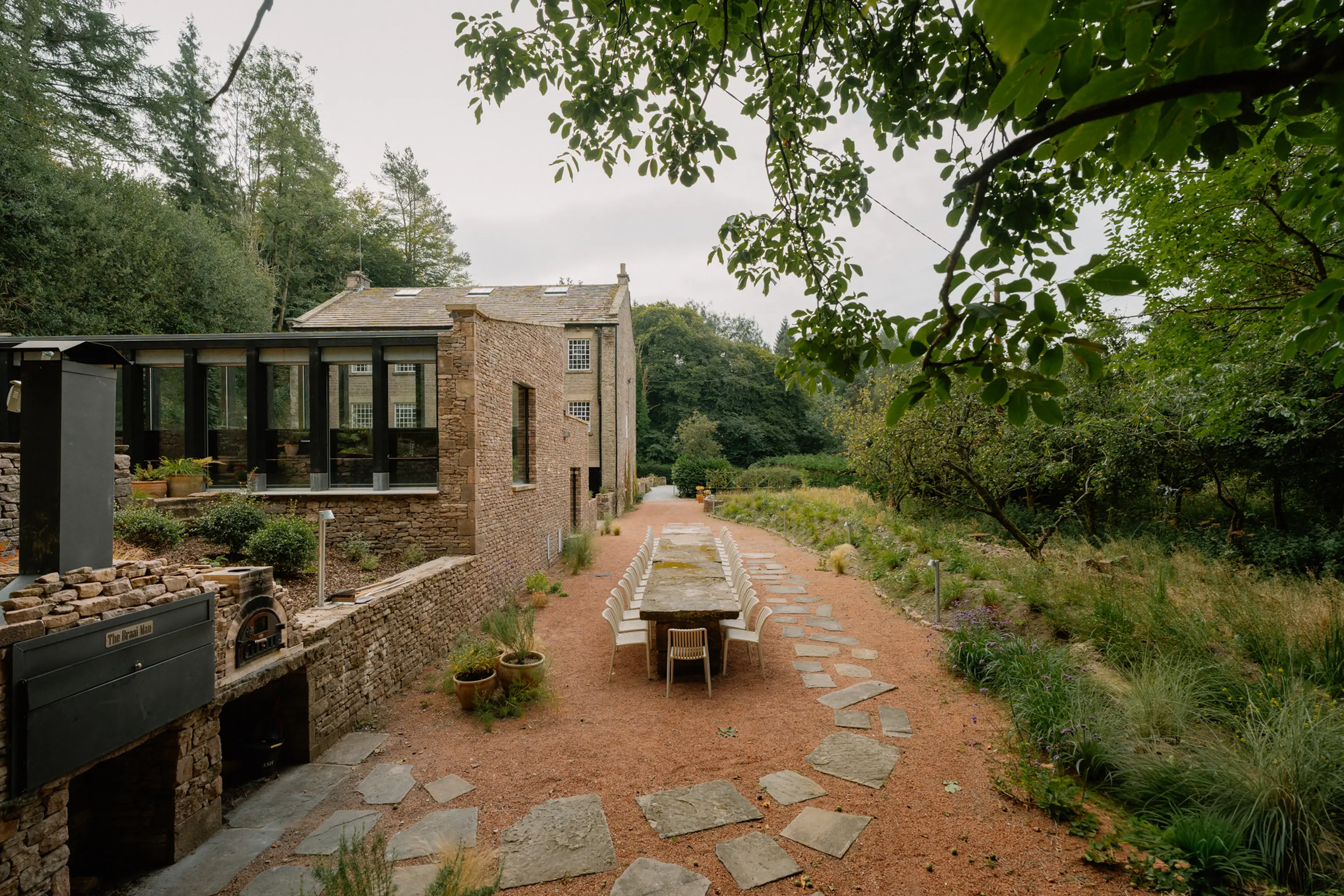 ARC Peaks, a stone former printworks with pool extension and long outdoor dining table