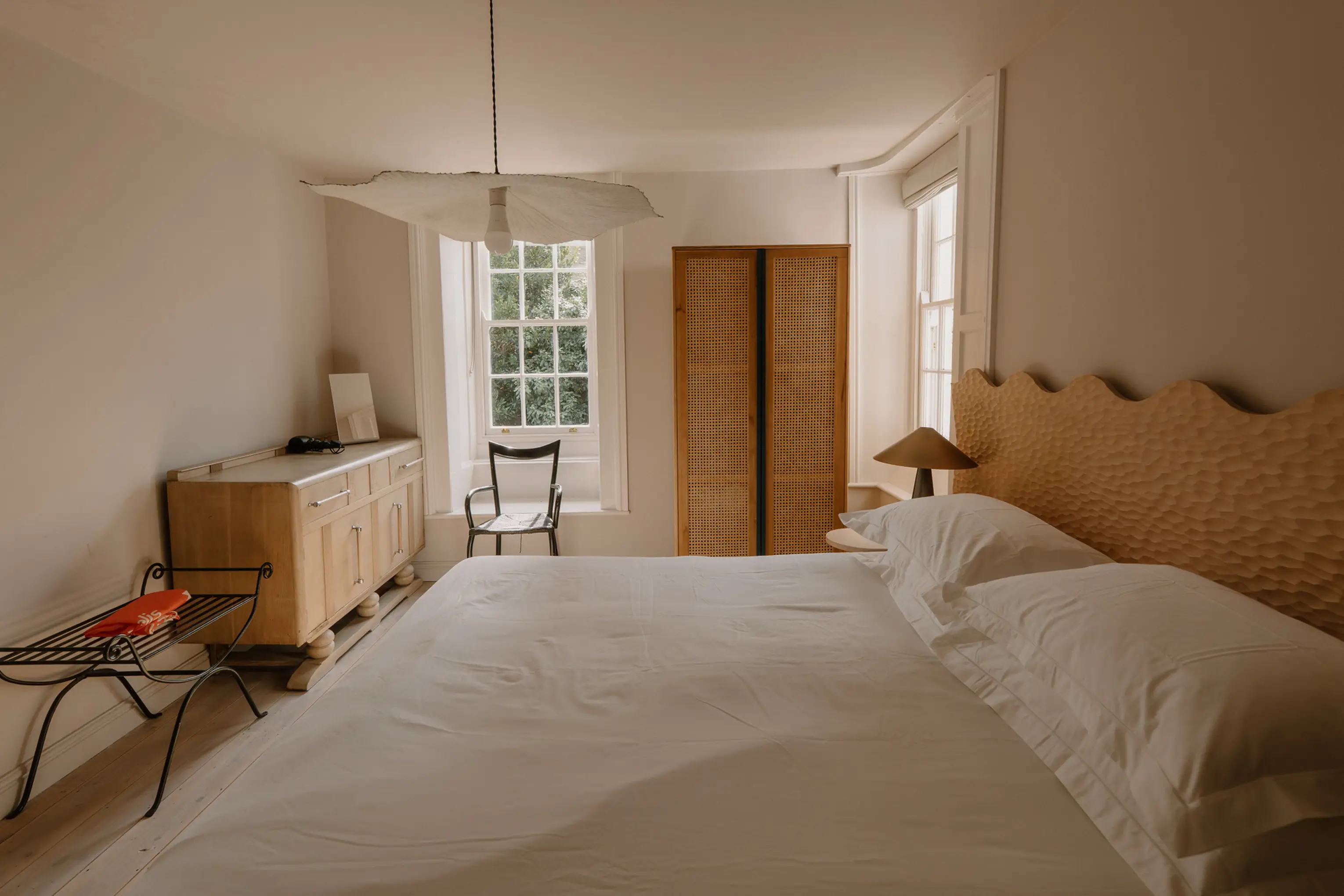 Light superking bedroom at ARC Padstow with a window seat, bench and sideboard