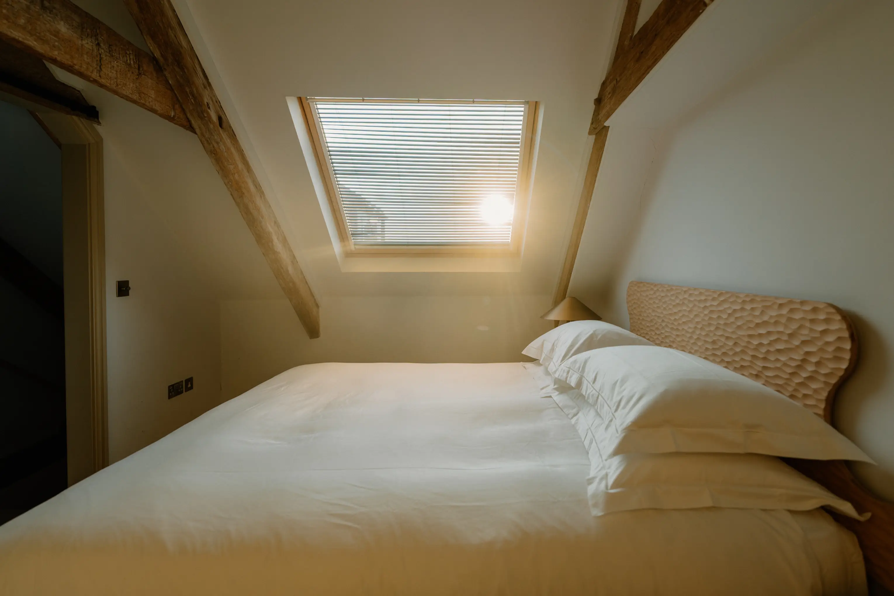 Eaves bedroom at ARC Padstow with a bed beneath a sloping ceiling and skylight