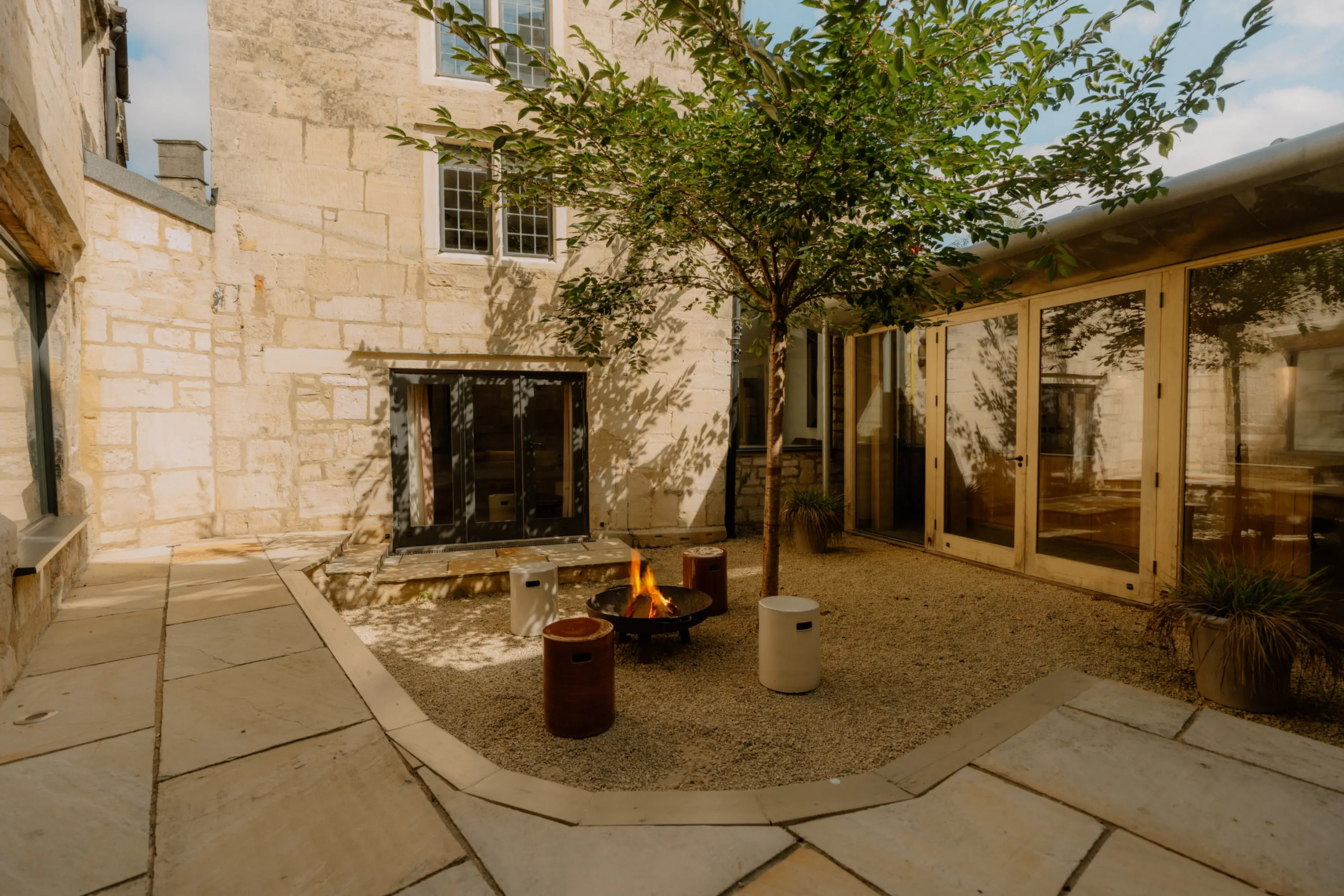 Internal courtyard at ARC Painswick with a potted tree and stone paving at dusk