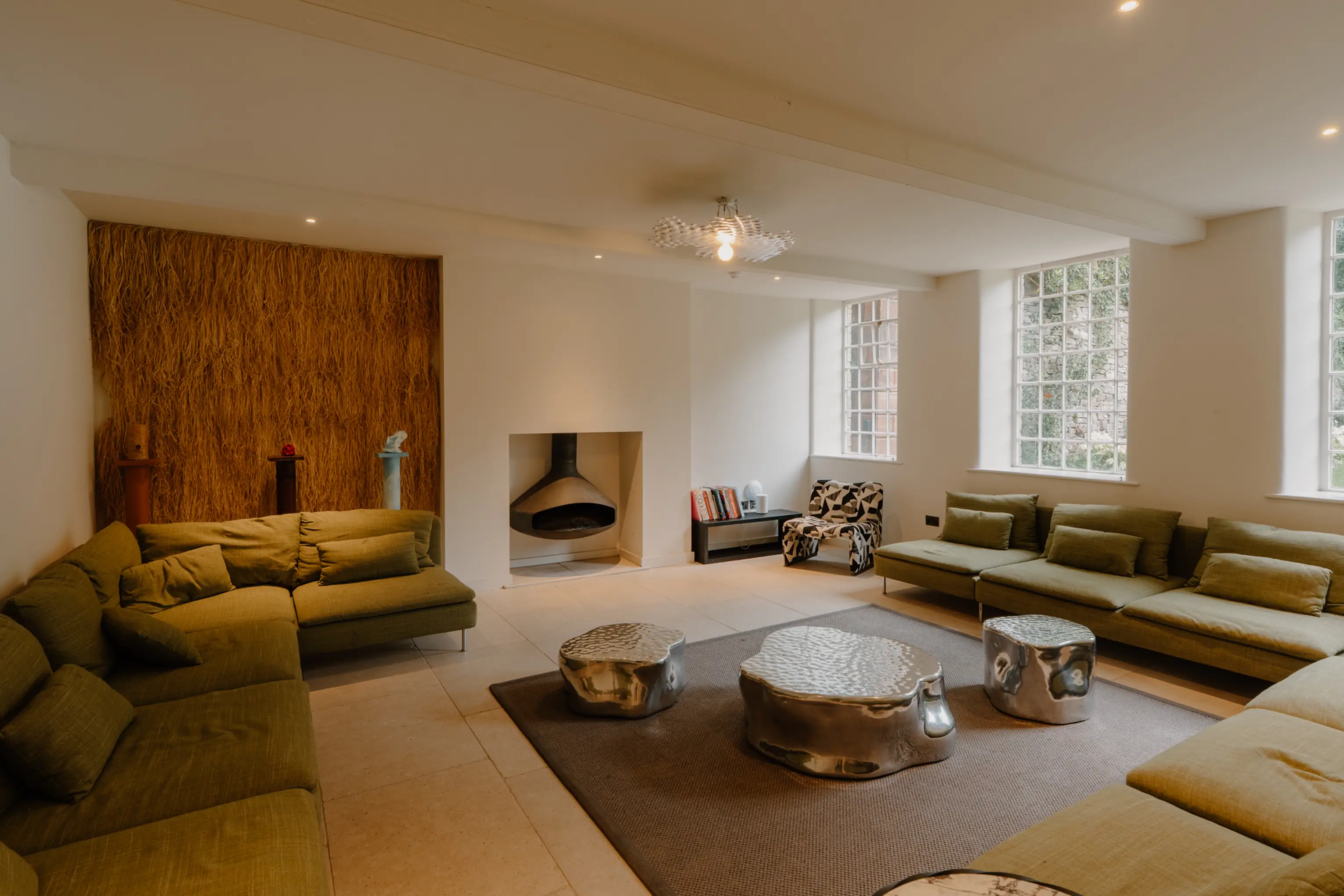 Large lounge at ARC Peaks with sectional sofas, a fireplace and a beamed ceiling