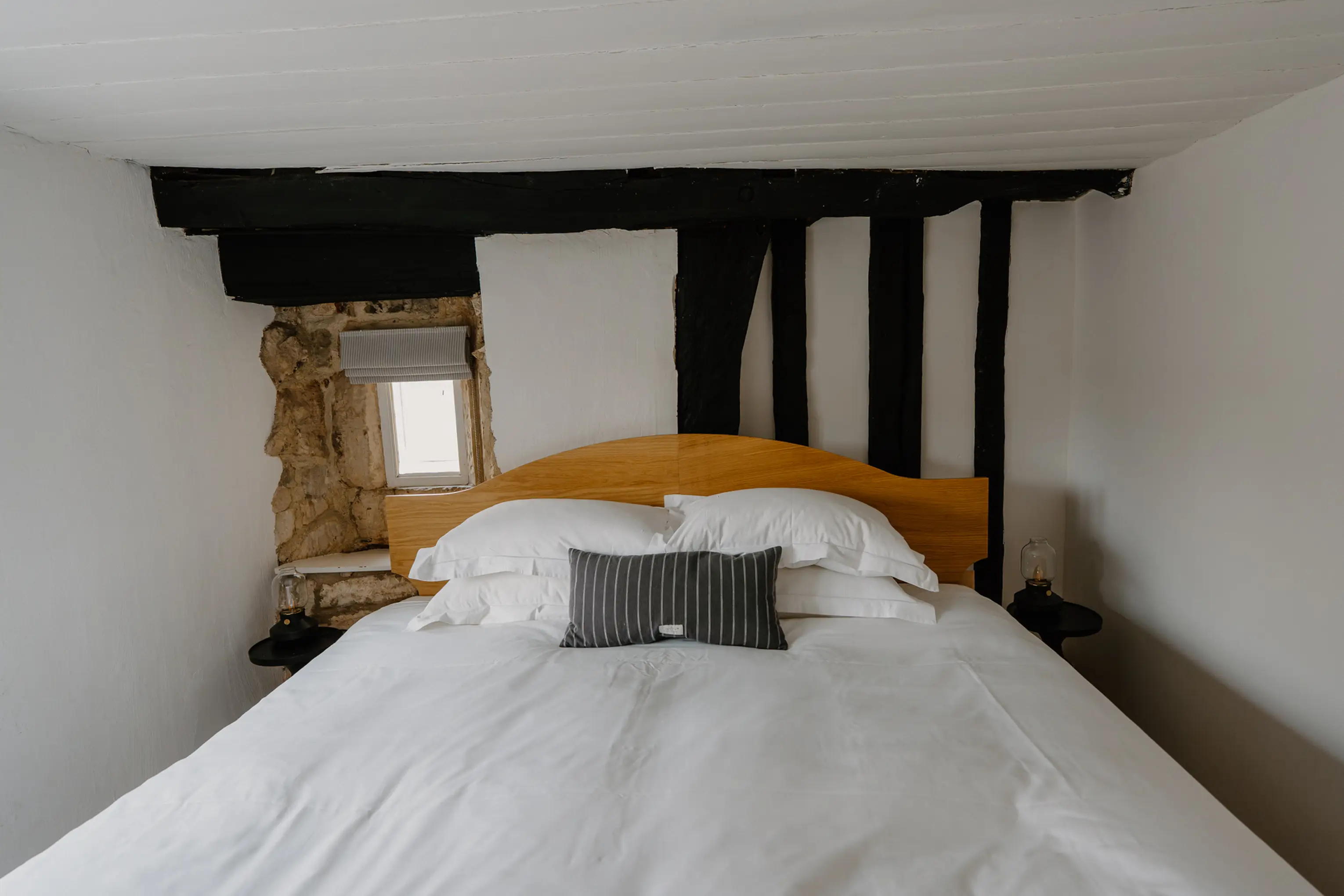Attic double bedroom at ARC Painswick with a timber headboard and exposed beam